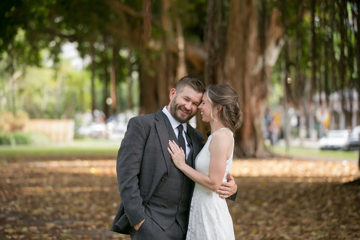 Couple laughing forehead to forehead under banyan trees at their St. Petersburg engagement session