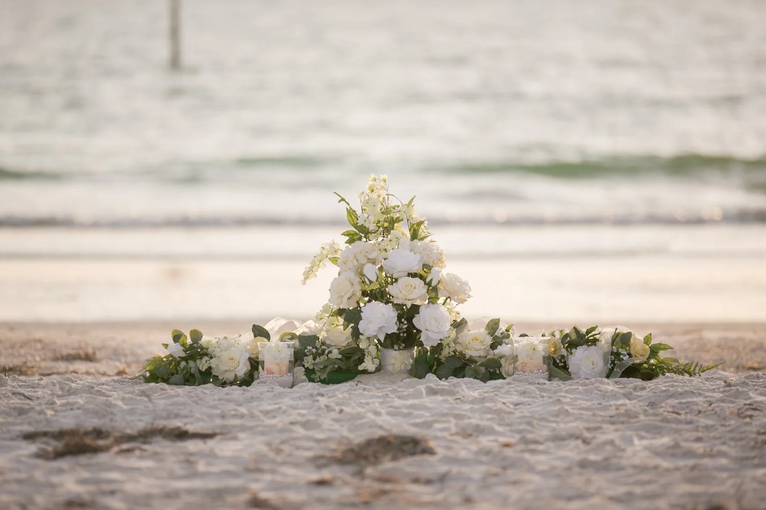 White rose and greenery proposal floral arrangement in the sand at Sand Key Beach