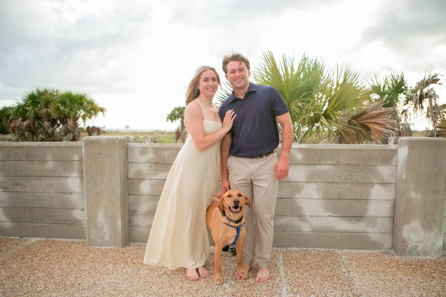 Newly engaged couple posing with their dog after the proposal