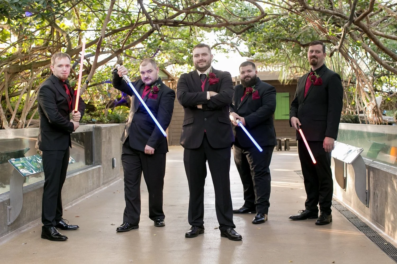 Groomsmen holding lightsabers on The Florida Aquarium boardwalk