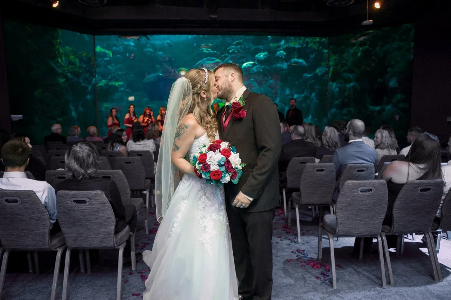 Newlyweds kissing as they walk back up the aisle