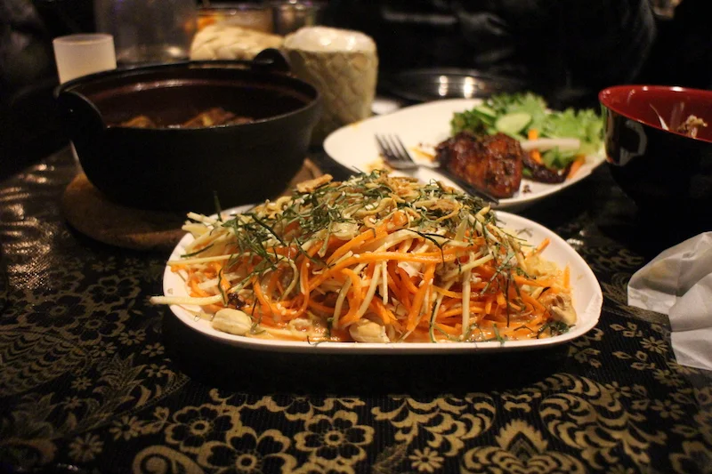 Yam Samun Phrai | Chiang Mai version of a Thai herbal salad with white turmeric, carrot, parsnip, betel leaf, basil, lime leaf, lemongrass, sawtooth, fried shallots, cashews, peanuts, sesame seeds, dry shrimp, ground pork and Thai chillies in a mild coconut milk dressing.