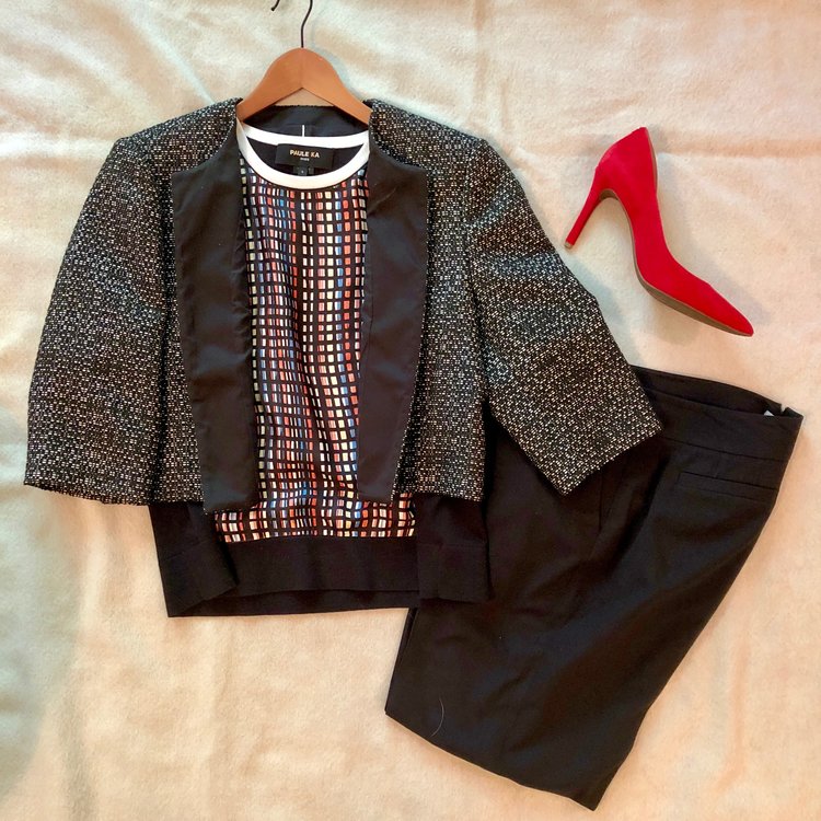 Yes, you can have fun at work by pairing a black and white textured jacket with a multicolored geometric print top. Black pants ground the look, and you can never go wrong with a pop color heel.