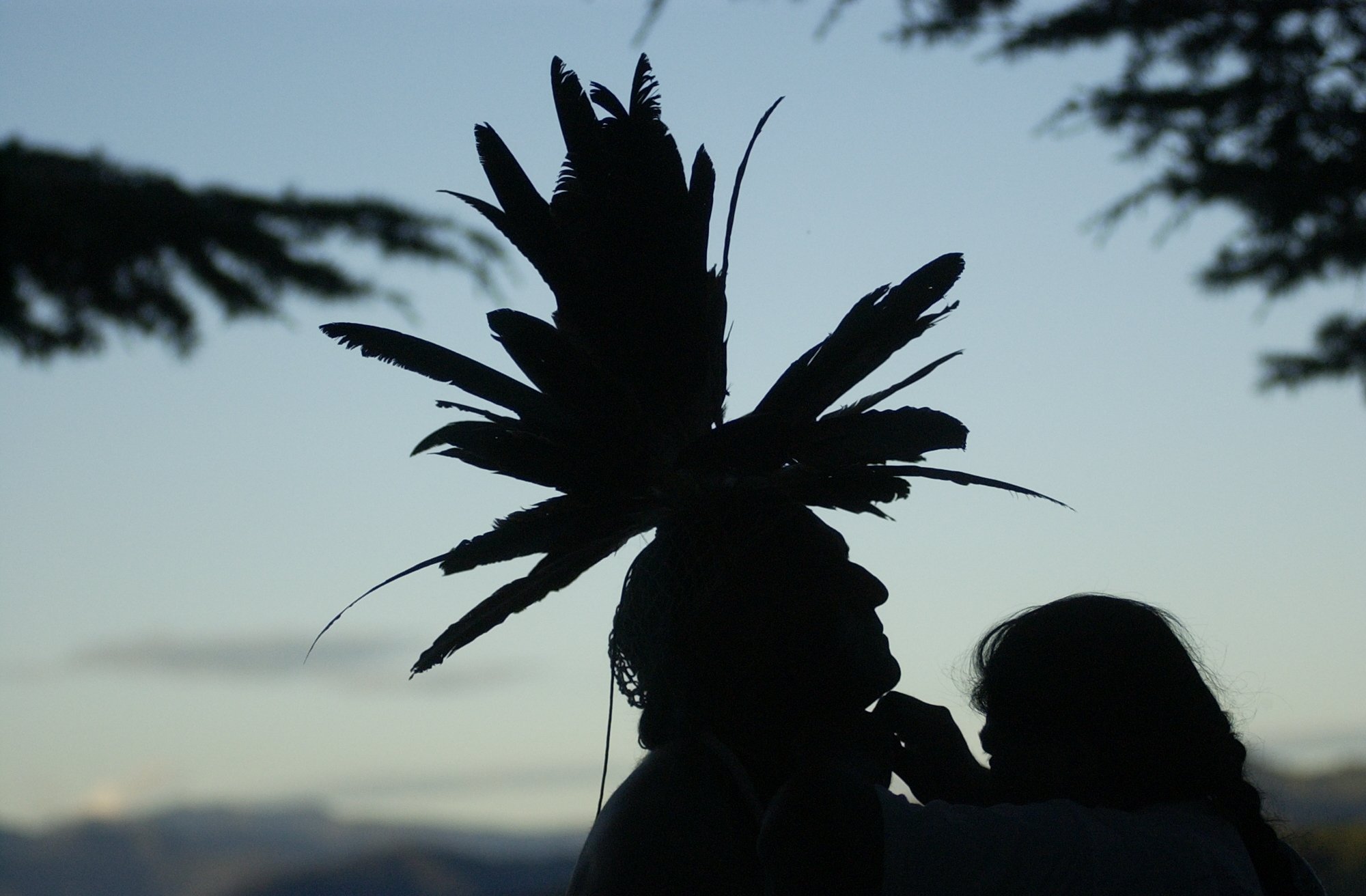  Mark Franco, headman of the Winnemem's Kerekmet Village, receives help putting on his headpiece from Randy Yonemura in preparation for the Winnemem war dance ceremony at Shasta Dam on Sunday. The Winnemem band of Wintu Indians is fasting and praying