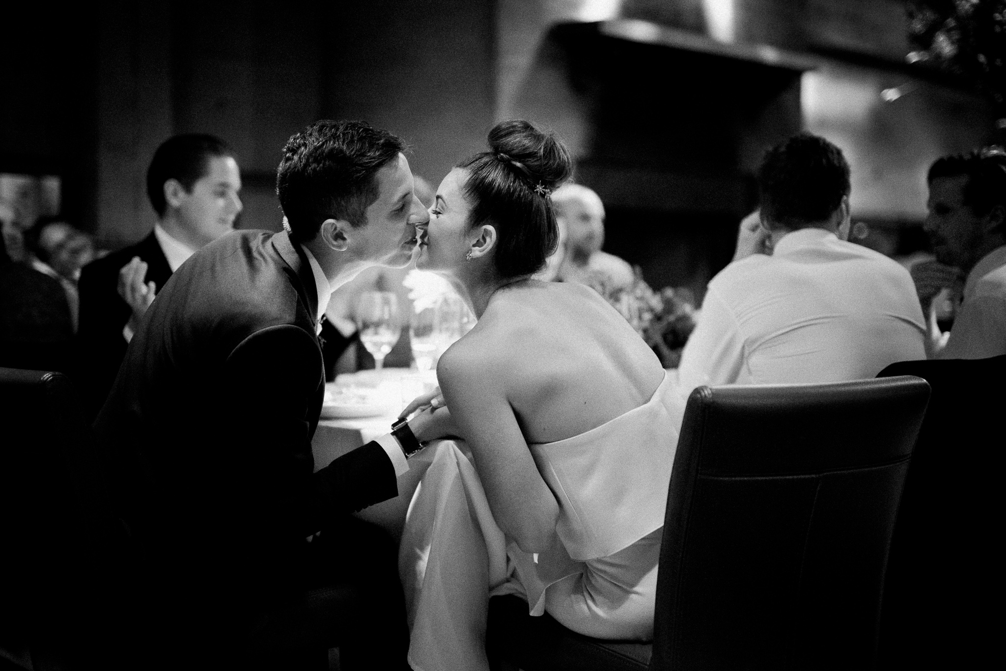 Bride and groom kissing at reception table at Foreign Cinema, San Francisco