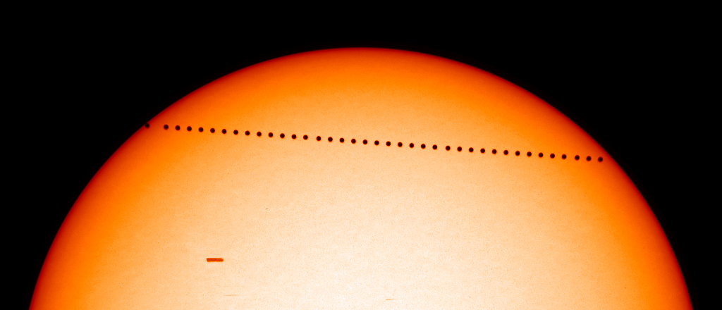 A transit of Mercury - the planet can be seen slowly moving across the face of the Sun.