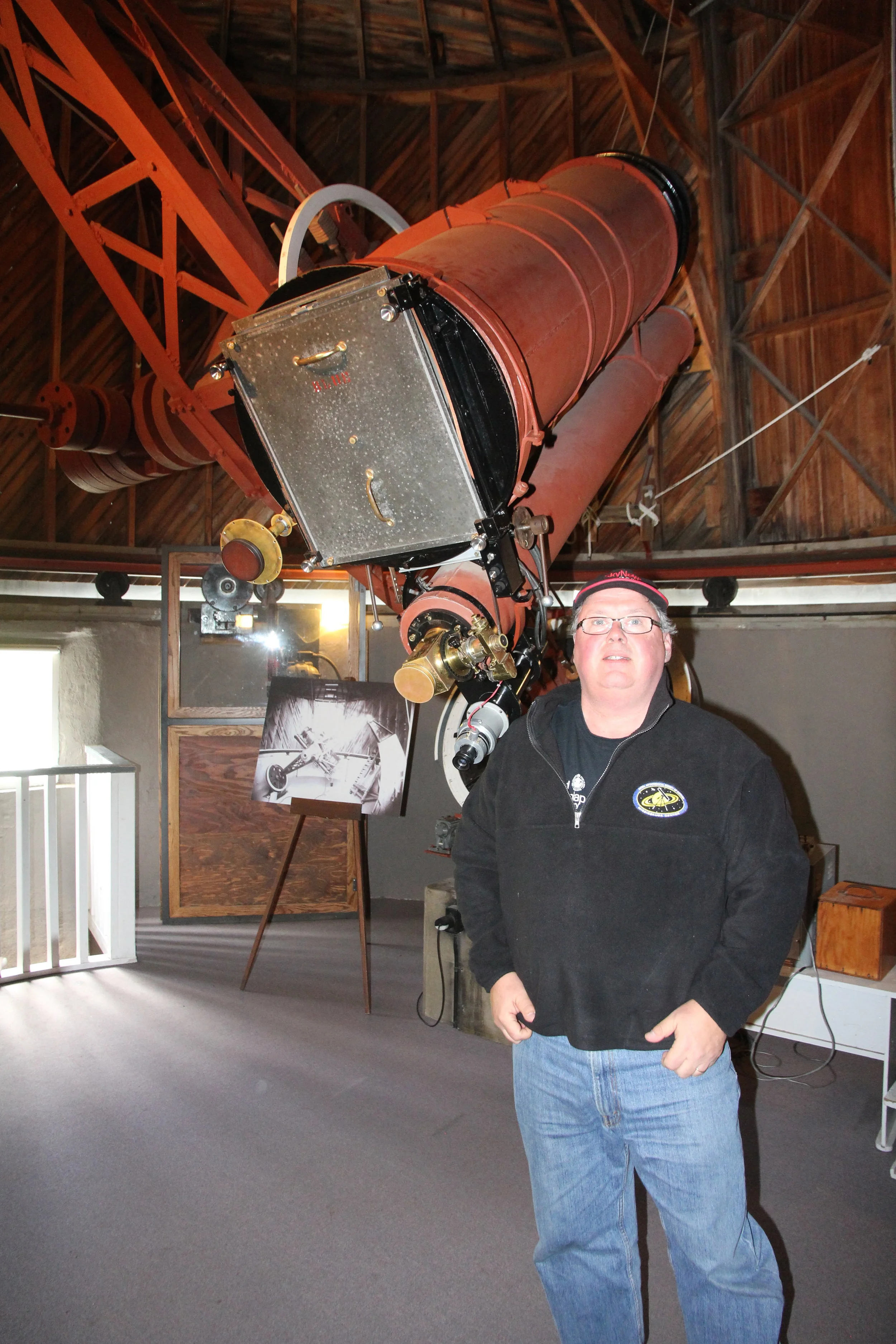Randy Attwood stands in front of the telescope/camera used to discover Pluto in 1930.