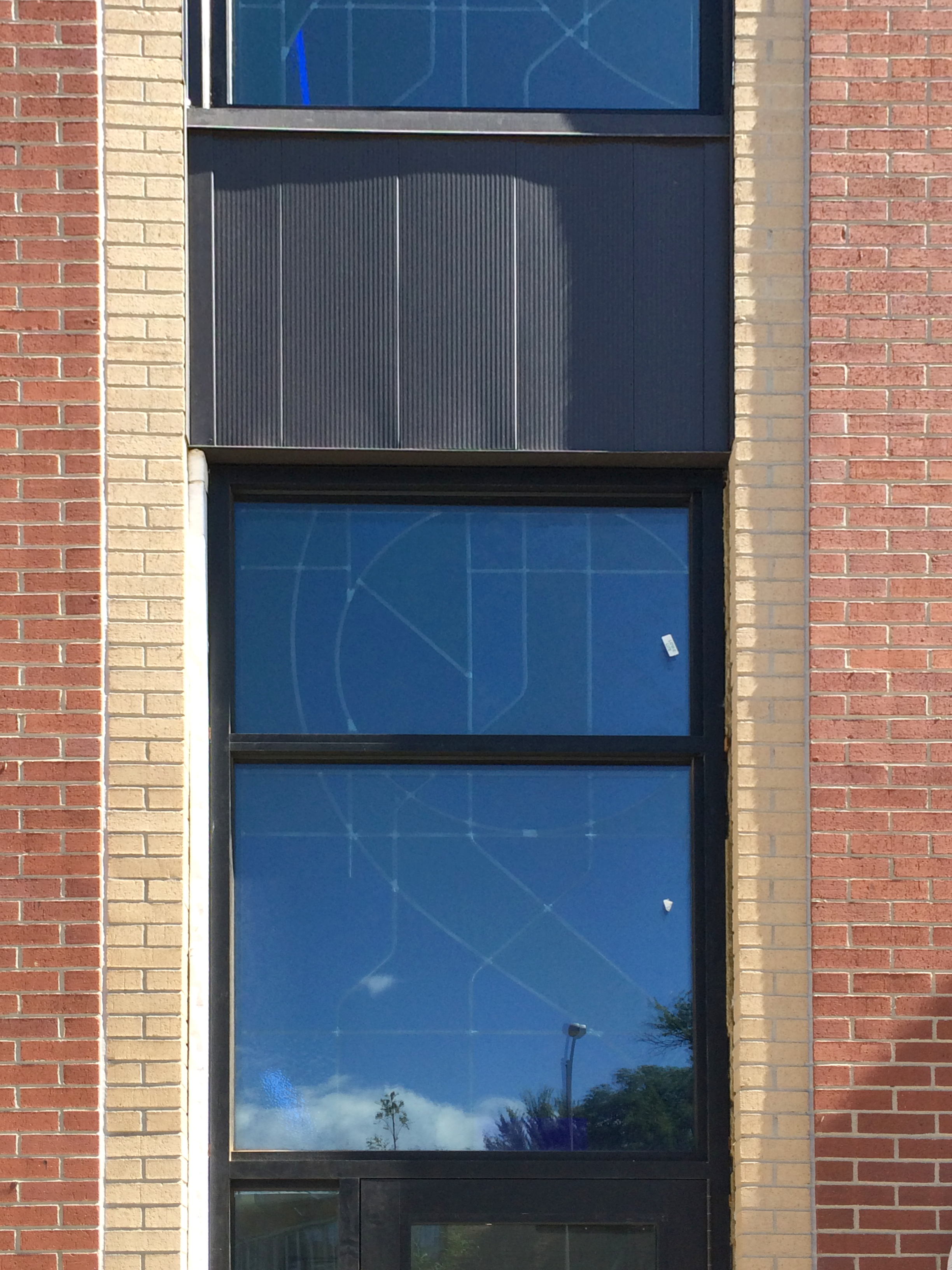 Brick Facade with stained glass visible behind.