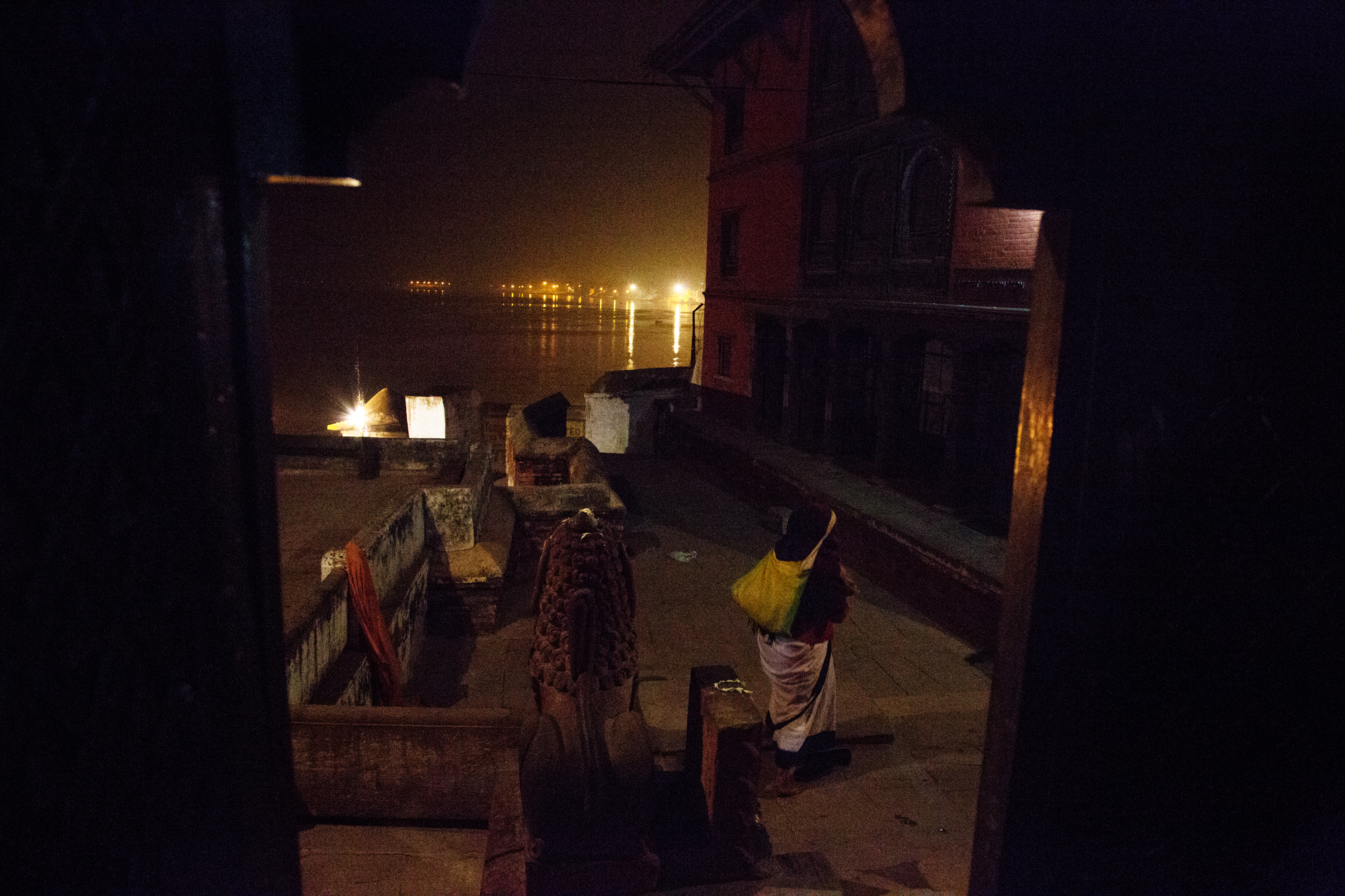  A woman leaves the temple to return to the ashram after evening Aarti. 