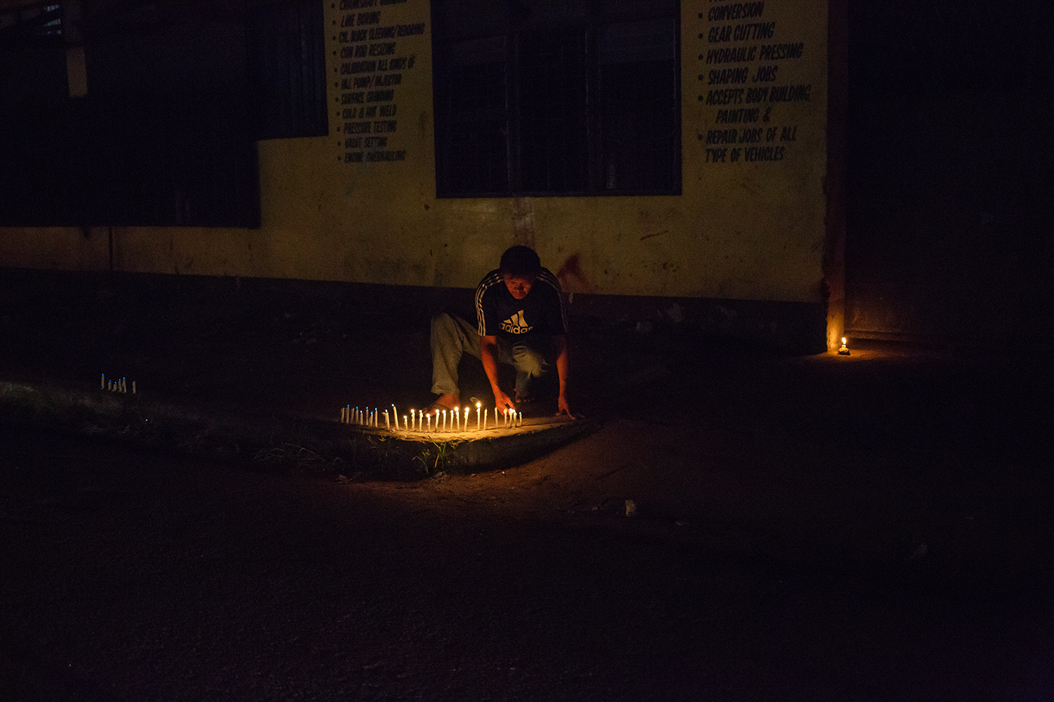  A man lights candles for loved ones lost on the one year anniversary of the landfall of Typhoon Haiyan in Tacloban, Leyte, the Philippines.&nbsp; 