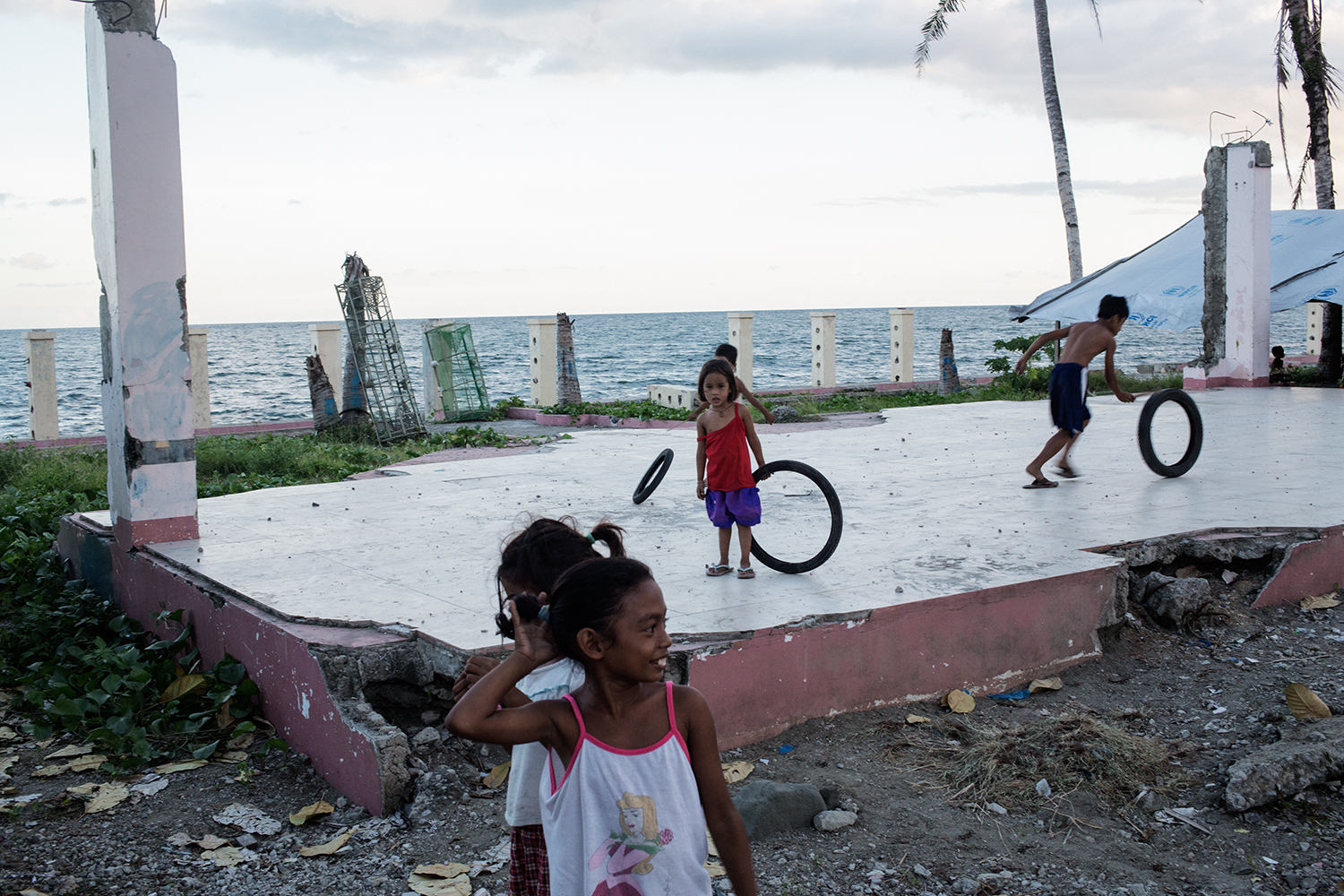 Children play in the ruins of a building in the tent village near San Jose airport, Tacloban City, Leyte in the Philippines on November 8, 2014 one year after the destruction of the landfall of Typhoon Haiyan. 