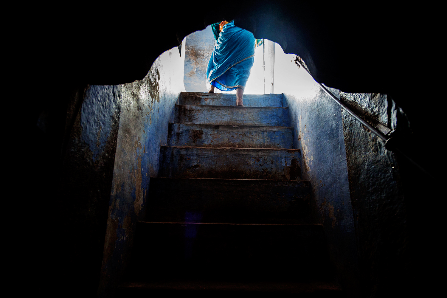  A woman walks upstairs to a communal area from her sleeping quarter in the ashram.   &nbsp;  