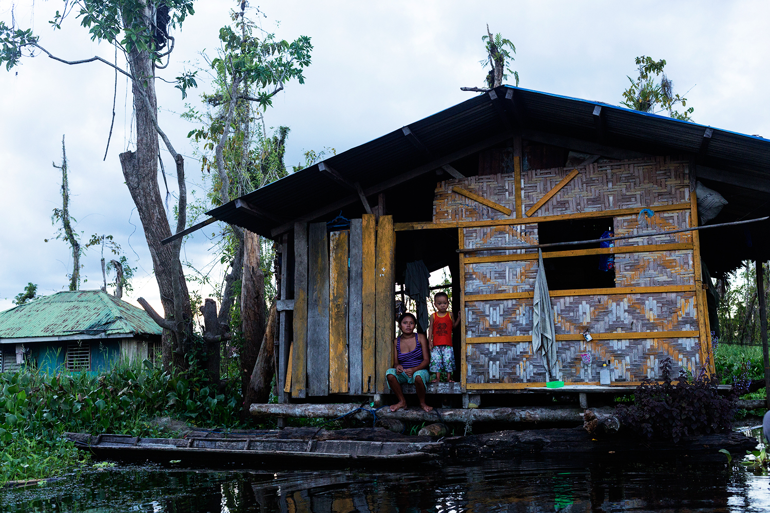  A woman and child sit on the front step of their floating home in the floating village in Agusan Marsh in Mindanao, the Philippines.&nbsp; 