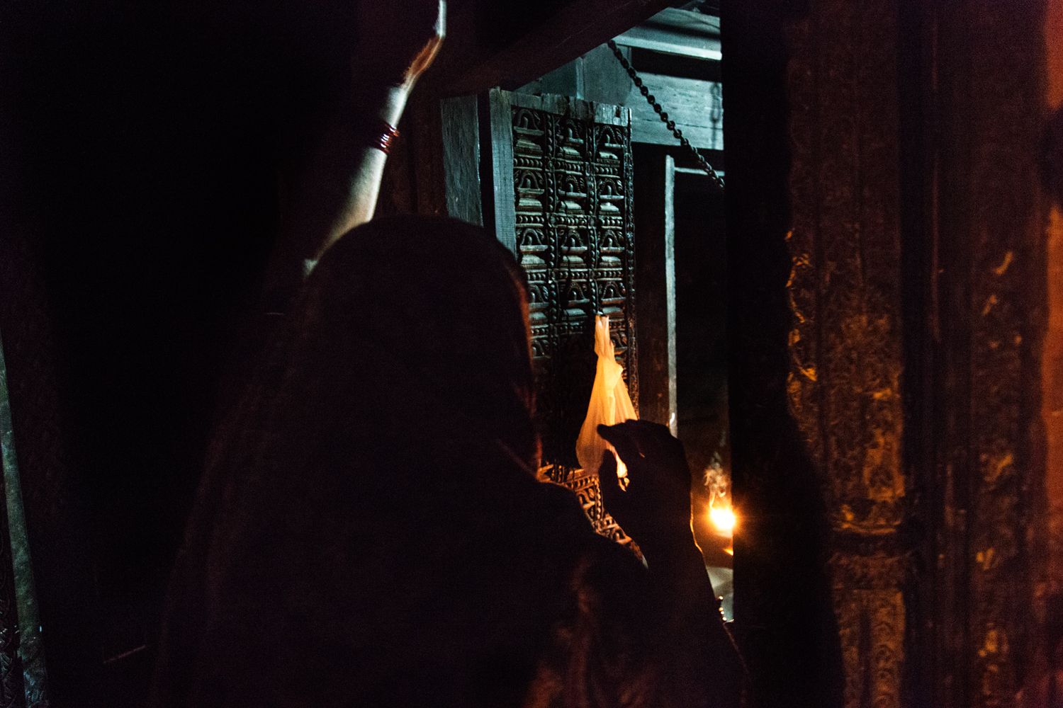 A woman rings a temple bell during evening Aarti. Bell ringing has an important significance during Aarti to welcome the gods into the idol so that devotees may be able to see his or her holy image in the ritualistic light.