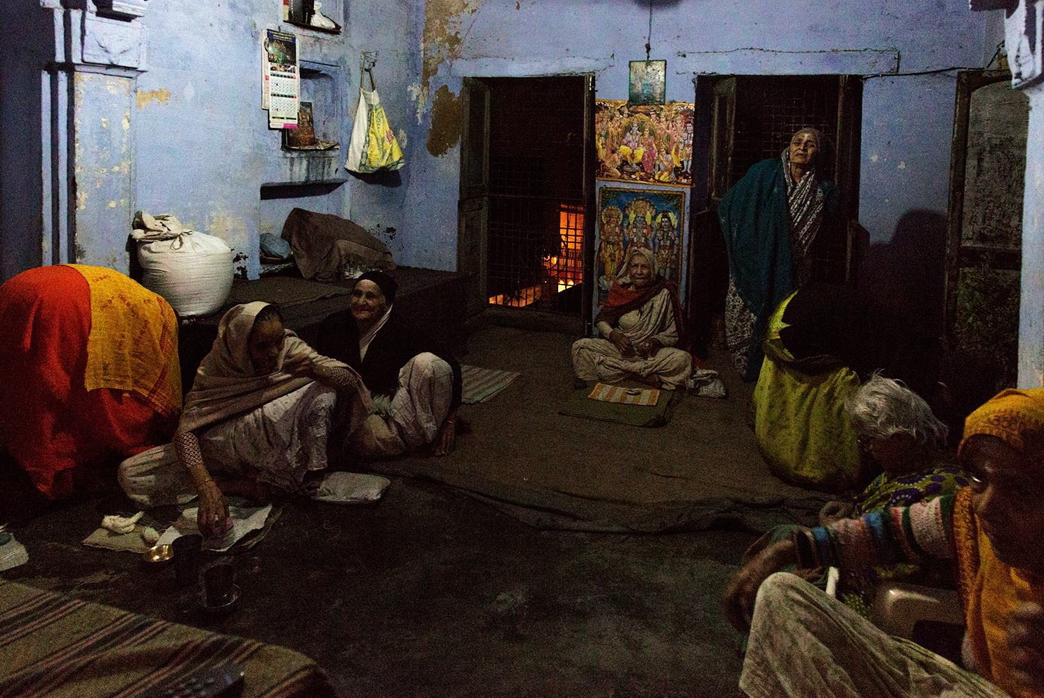 Women relax together and watch television in the ashram after evening Aarti.