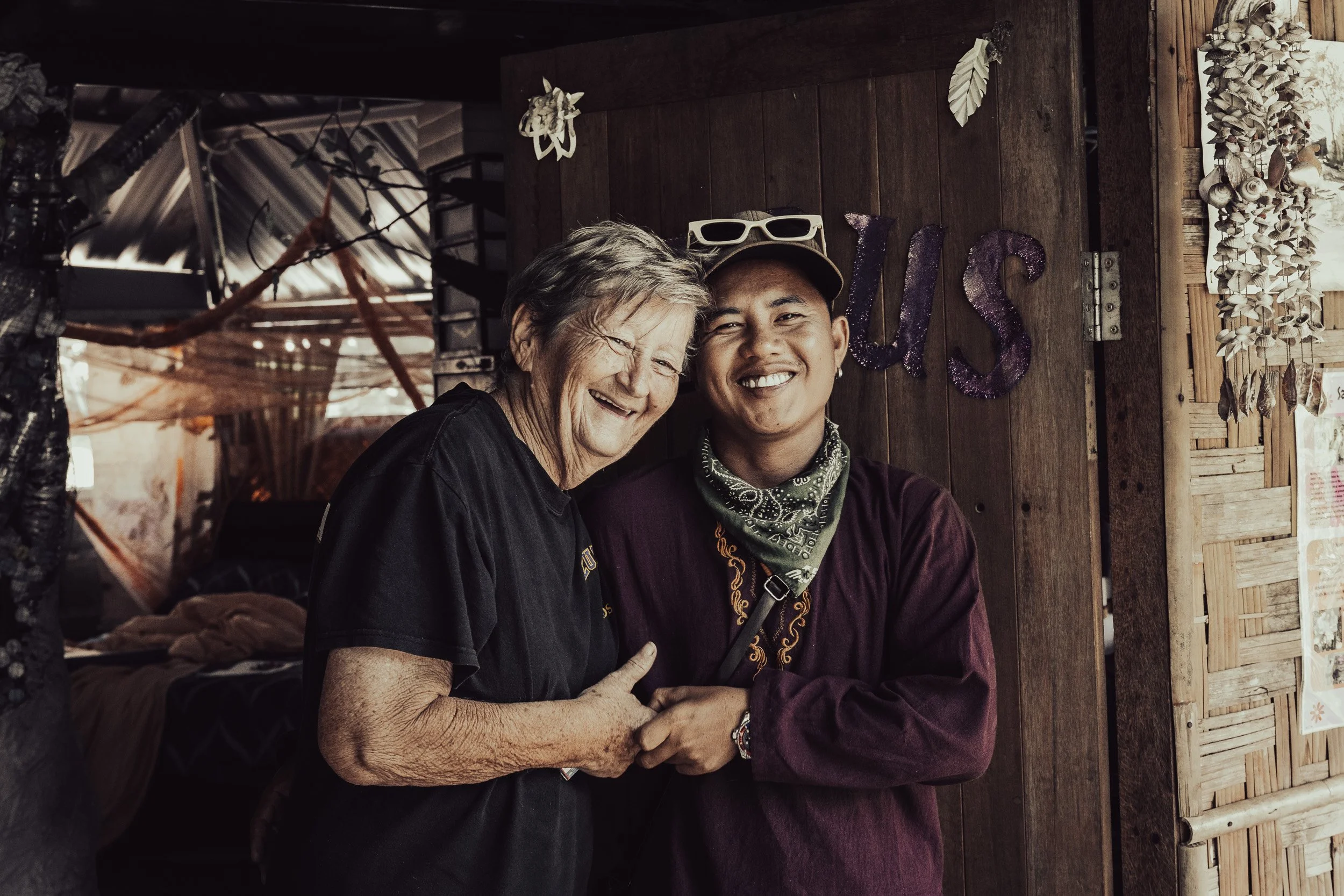 Documentary photo of Momo Cat hugging former student Ahmorthay at The Bamboo School, Thailand.