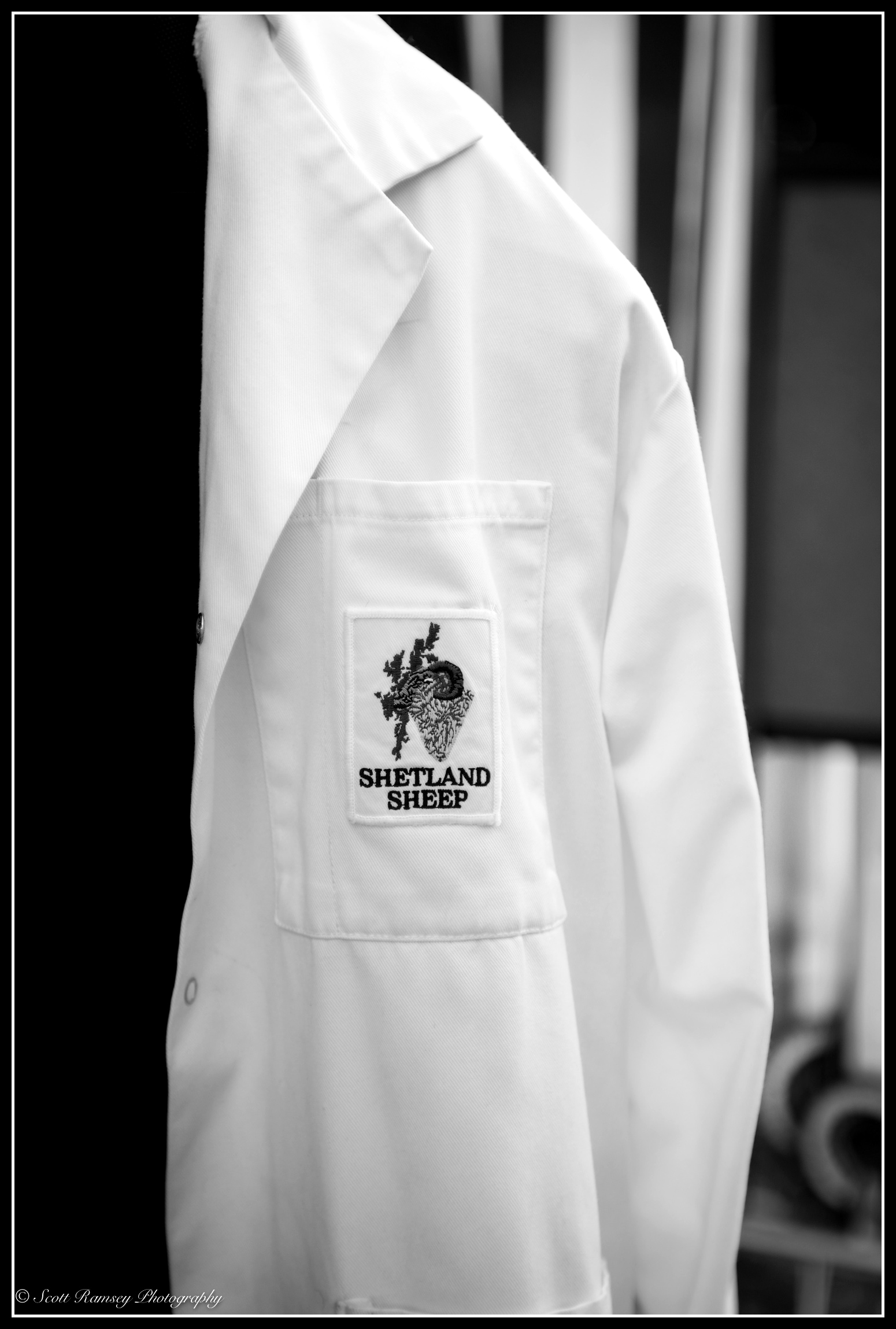 A white coat with a Shetland Sheep badge on it hanging up at the Findon Sheep Fair in West Sussex.