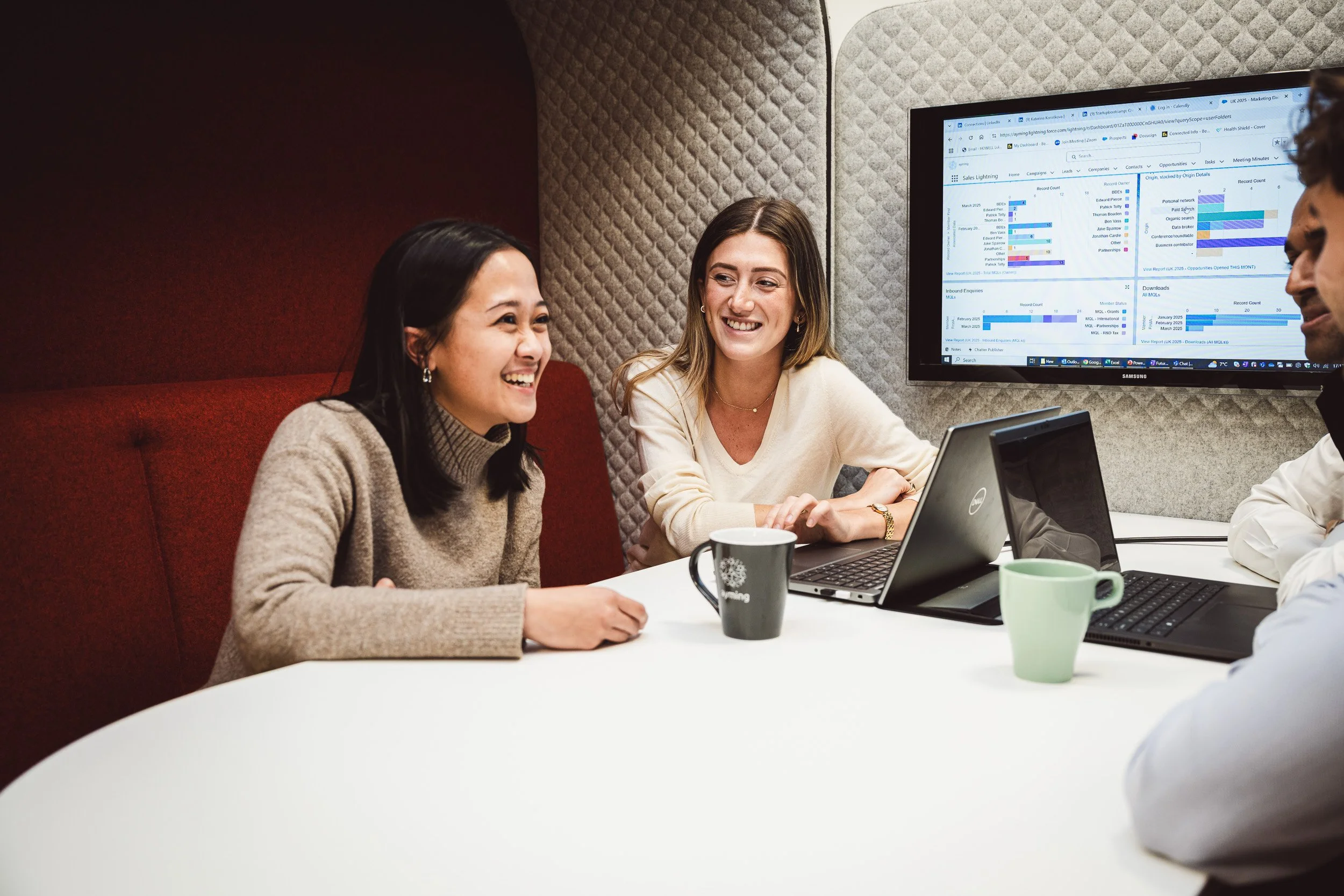 Natural and authentic corporate culture photography featuring two business professionals collaborating in a modern office breakout space, demonstrating brand-led lifestyle imagery.