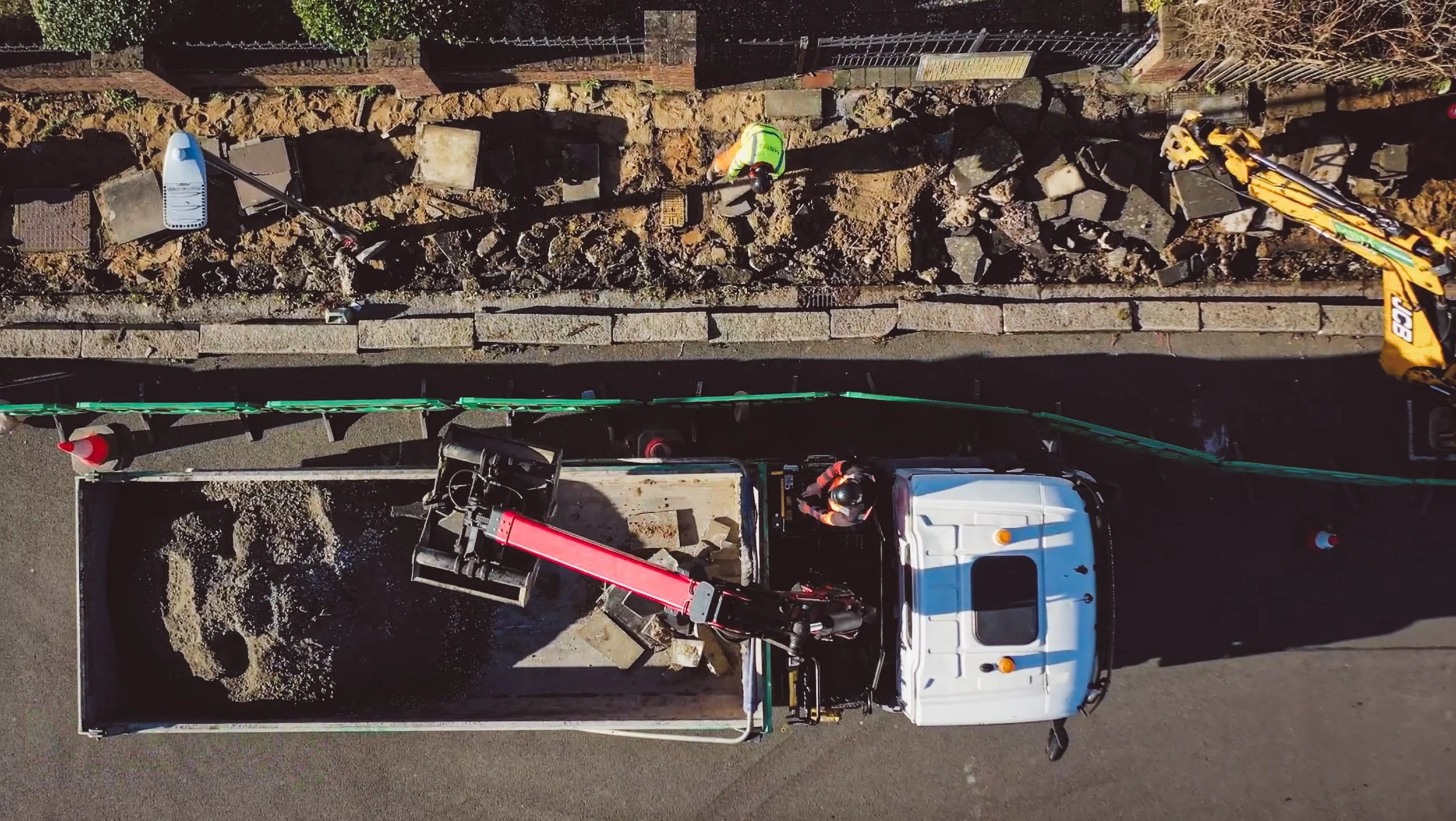 Professional overhead drone photography of an MBM Groundworks construction site in London, documenting crane logistics and pavement infrastructure for a high-scale industrial project.
