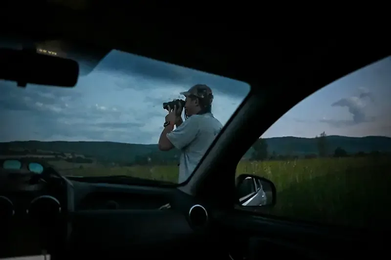 A bear conservation ranger scans the horizon at dawn in the Carpathian Mountains. Scott Ramsey documents the quiet dedication of experts managing wildlife coexistence in the Romanian wilderness.