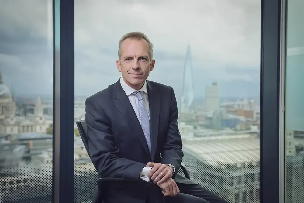 A cinematic, high-end portrait of a senior corporate executive in a London office, captured by a professional corporate videographer to demonstrate broadcast-quality lighting and executive presence.