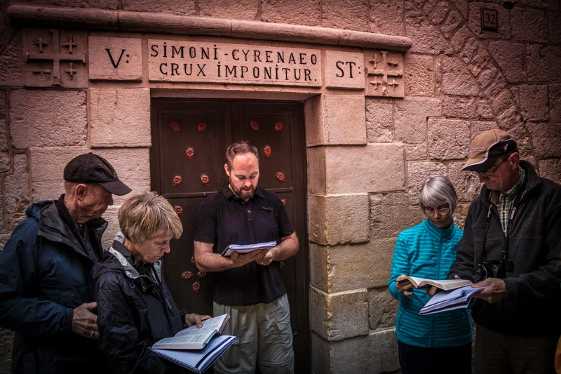 Walking the traditional Via Dolorosa, the Way of Jesus' Suffering, and reflecting at Station Five marking Simon of Cyrene being compelling to carry Jesus' cross.