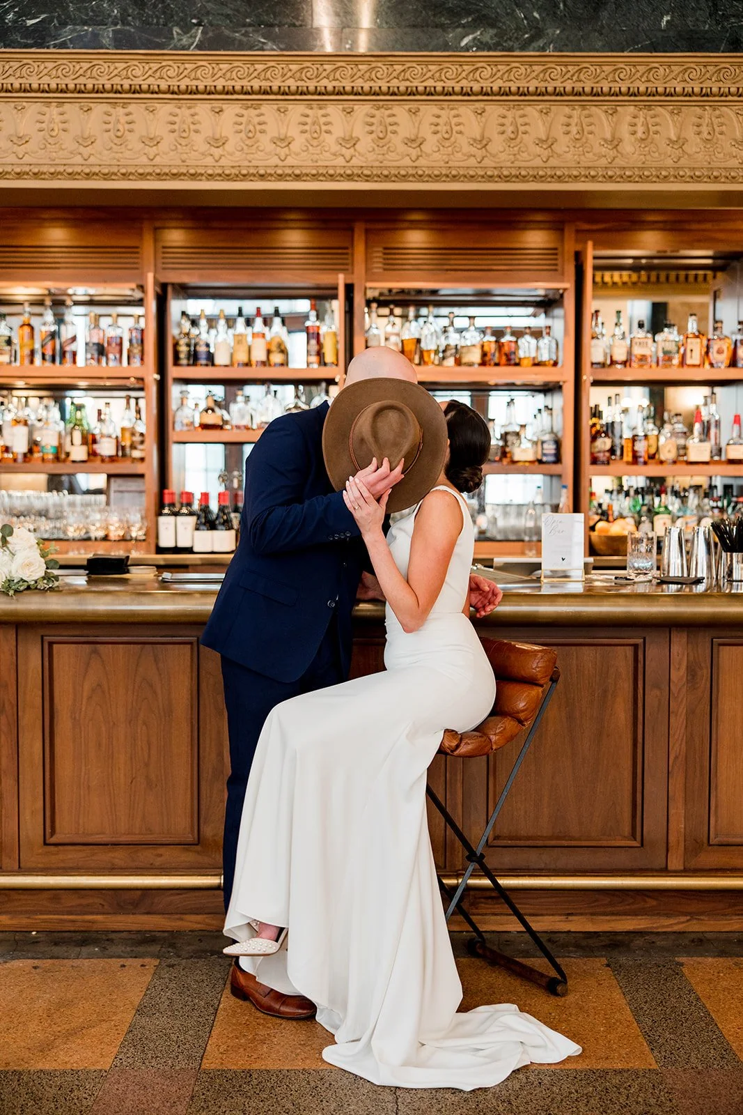bridal-couple-kissing-behind-hat.jpg