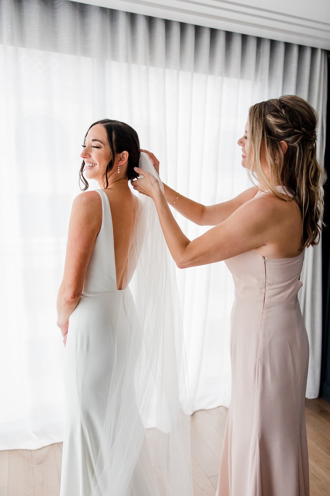 bridesmaid-putting-brides-veil-on.jpg