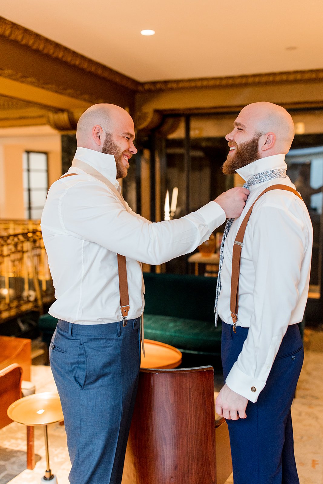 groomsman-putting-grooms-tie-on.jpg