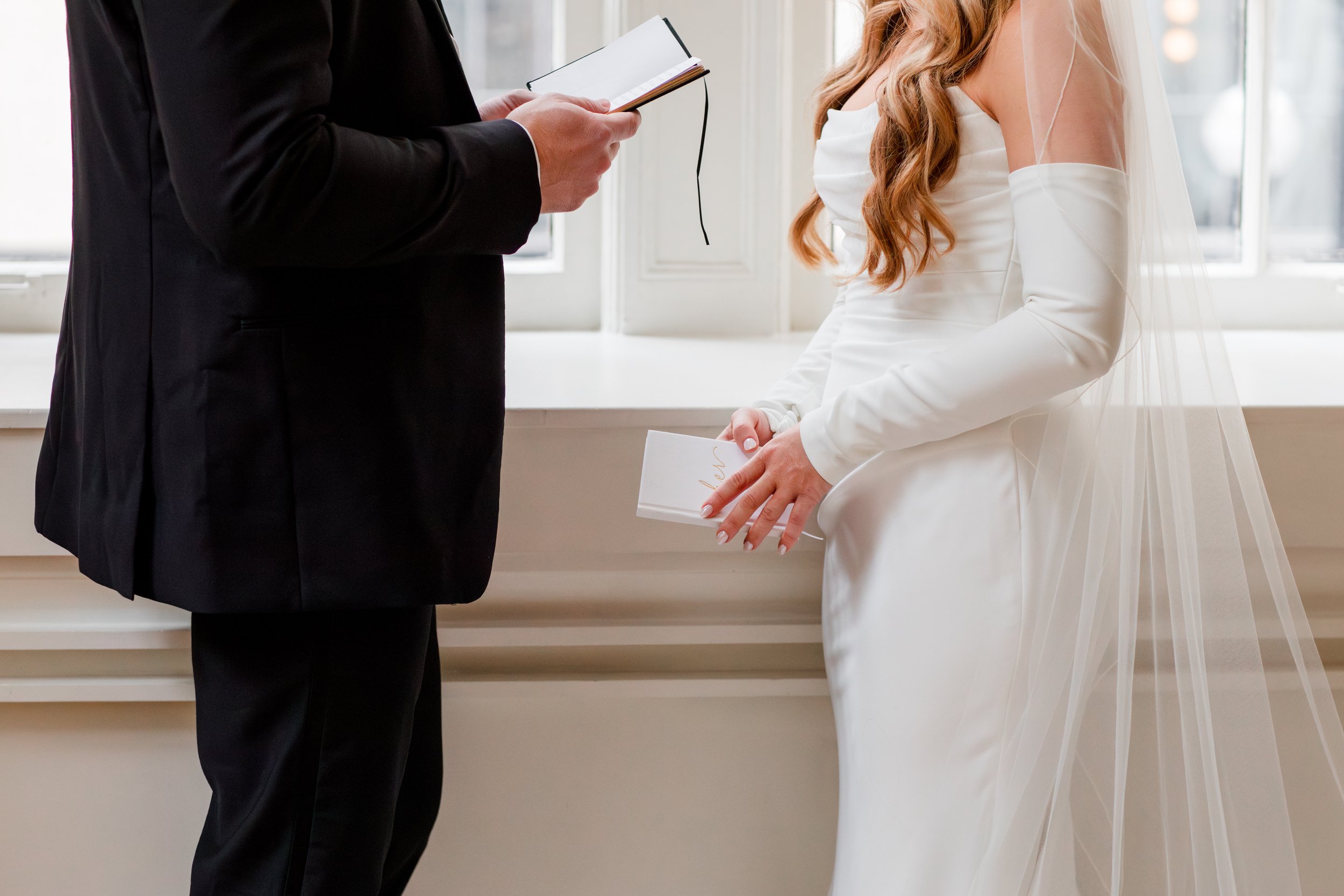 bride-and-groom-holding-vow-books.jpg