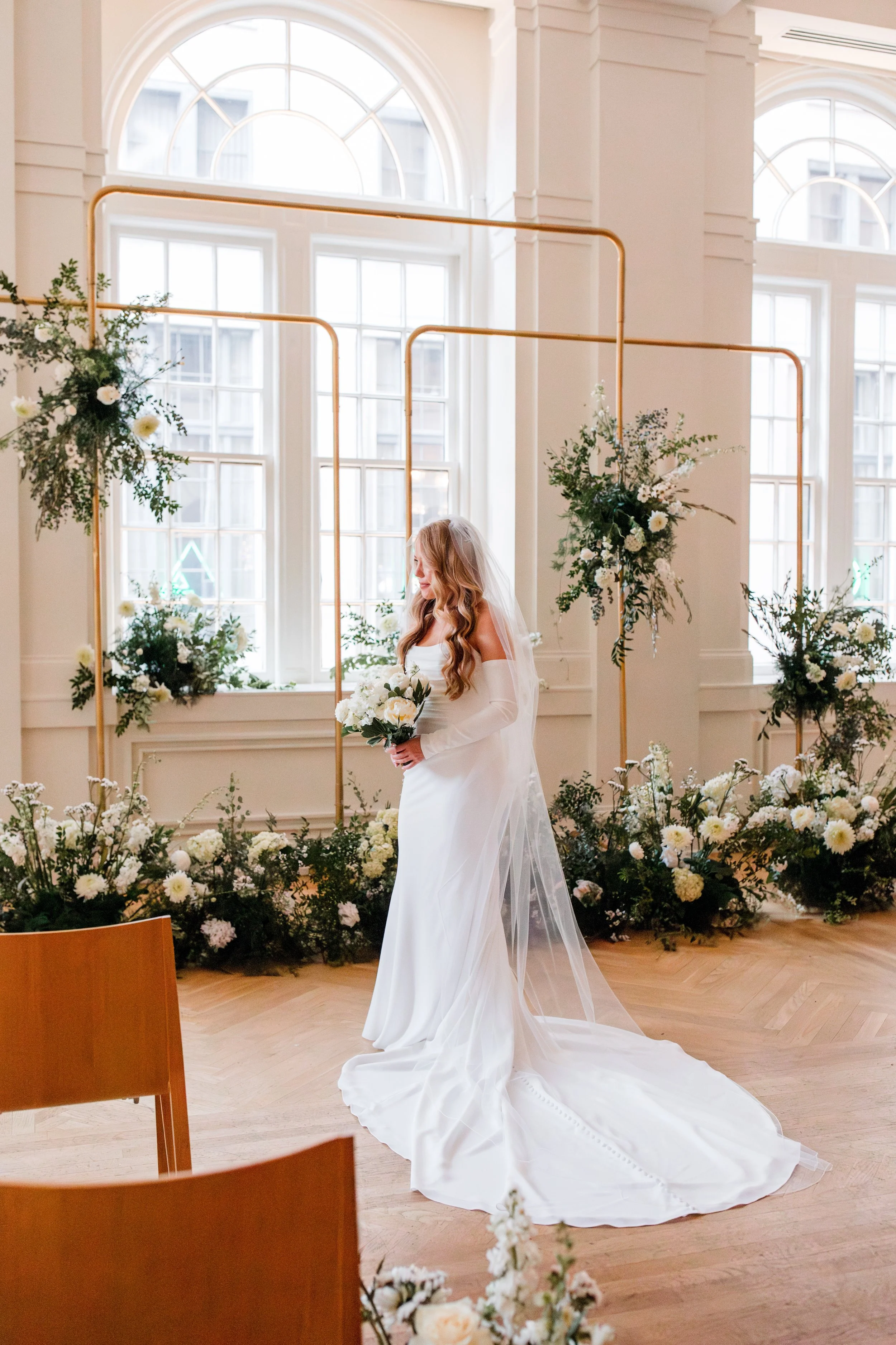 bride-standing-by-floral-altar.jpg