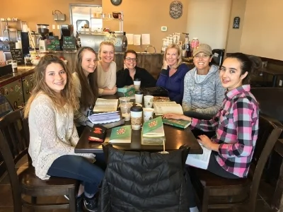 Moms and daughters and aunties reading "None Like Him." 