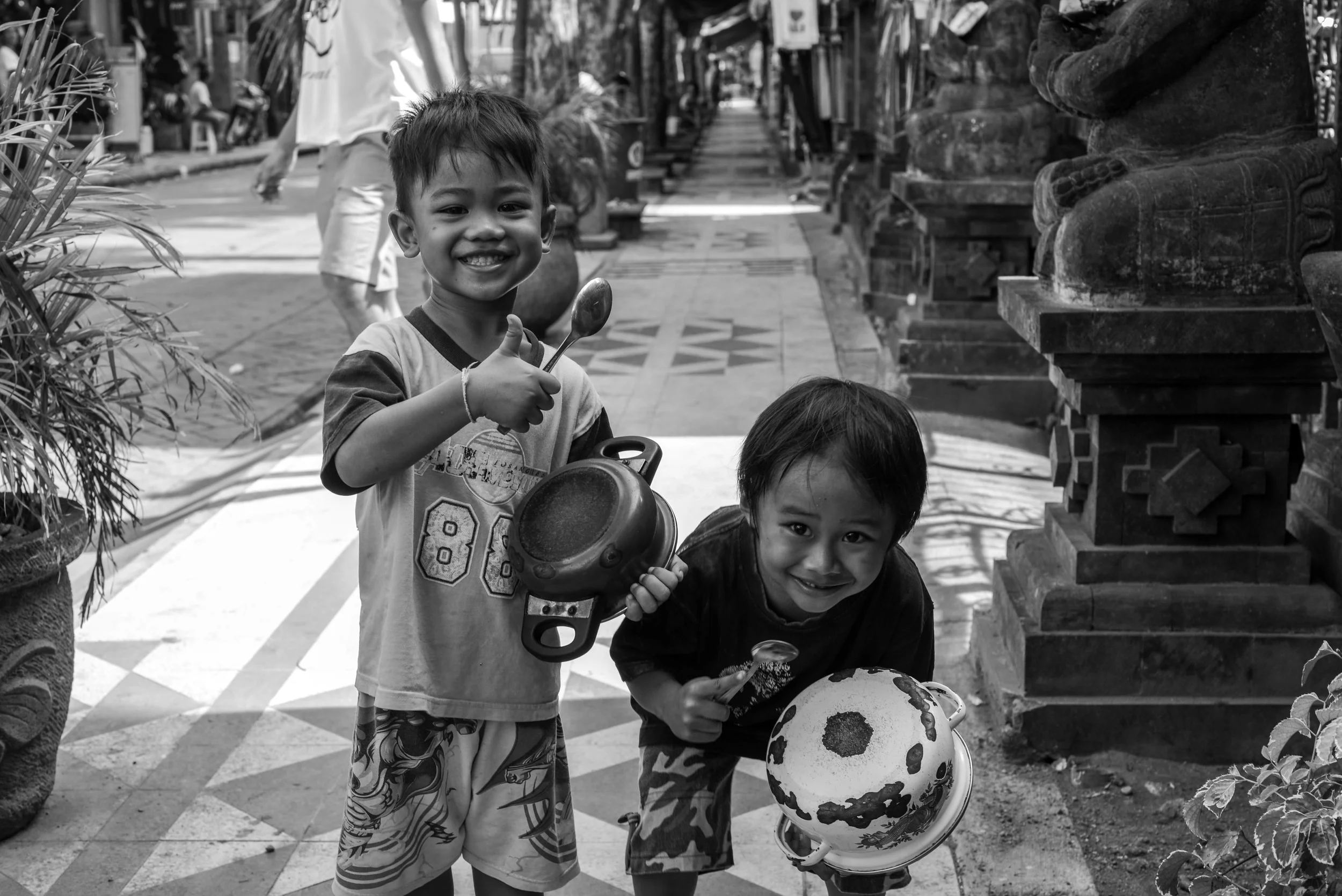 Very happy local kids playing pots and pans in Kuta.