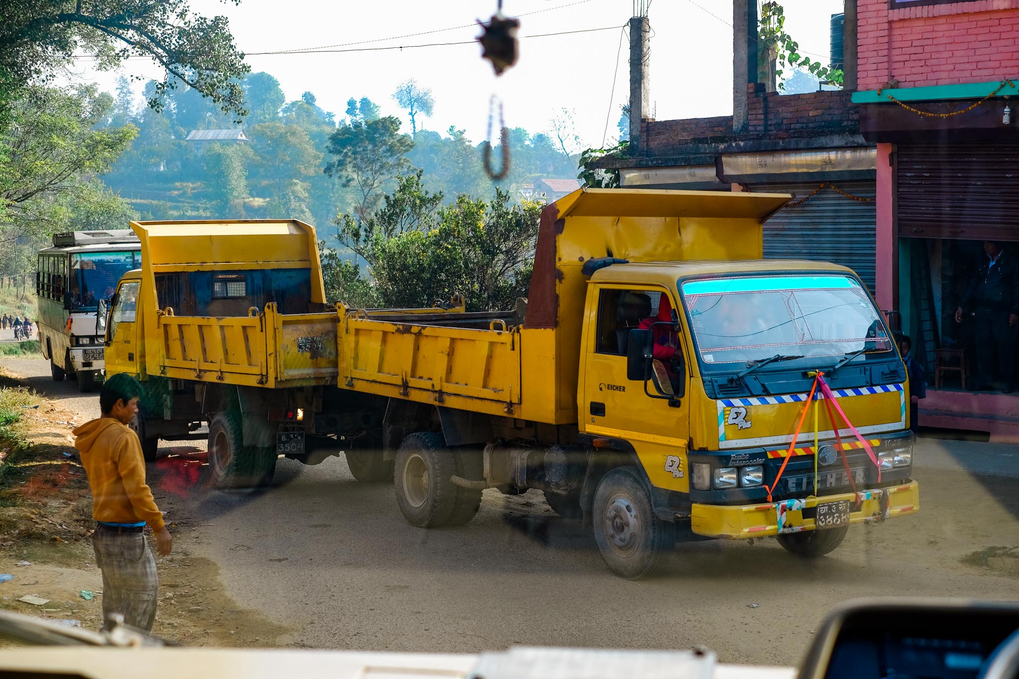 3/4 of the way to the school the road was blocked by these two tip trucks. One had to push the other down the hill to jump start it and eventually after 5 minutes the road was free again. 