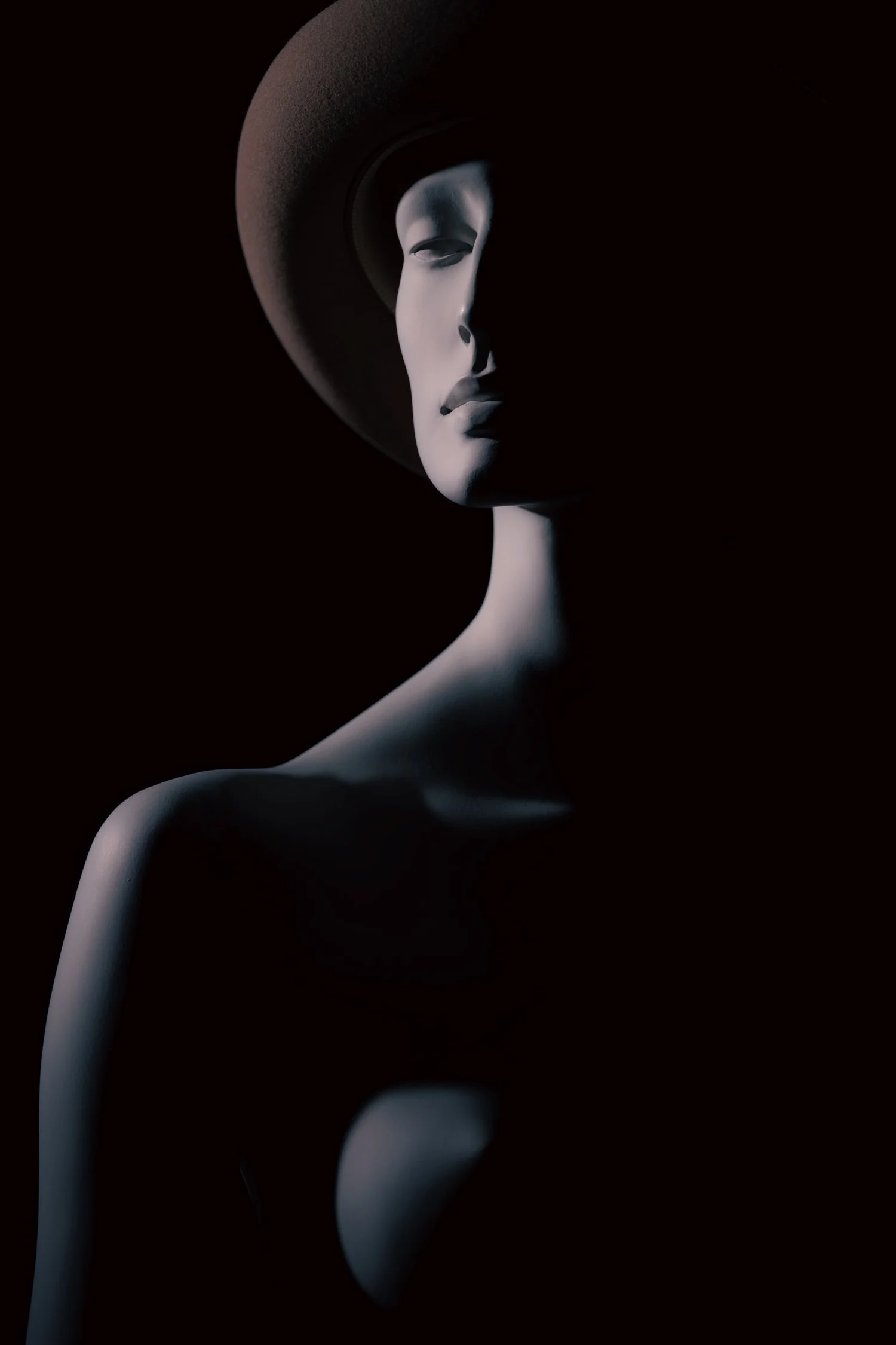 Cinematic light study featuring a nude mannequin wearing a fedora.