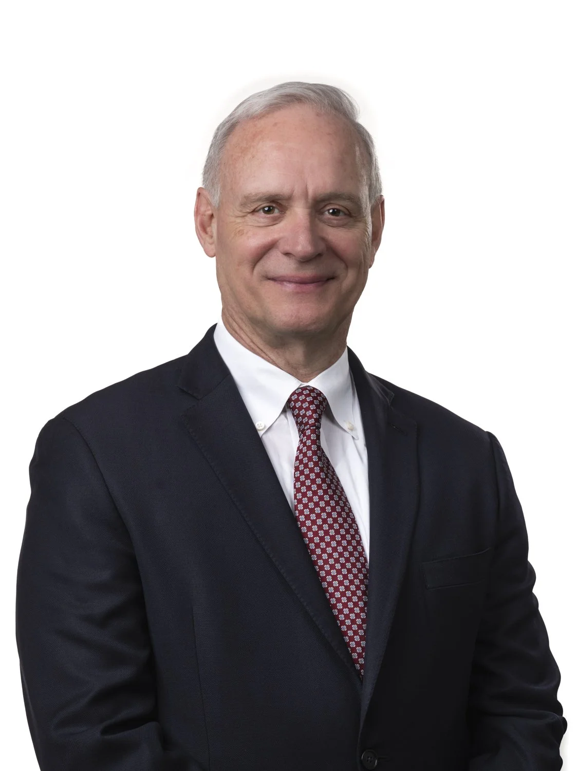 Corporate headshot of professional man in a suit and tie, photographed against a white background.