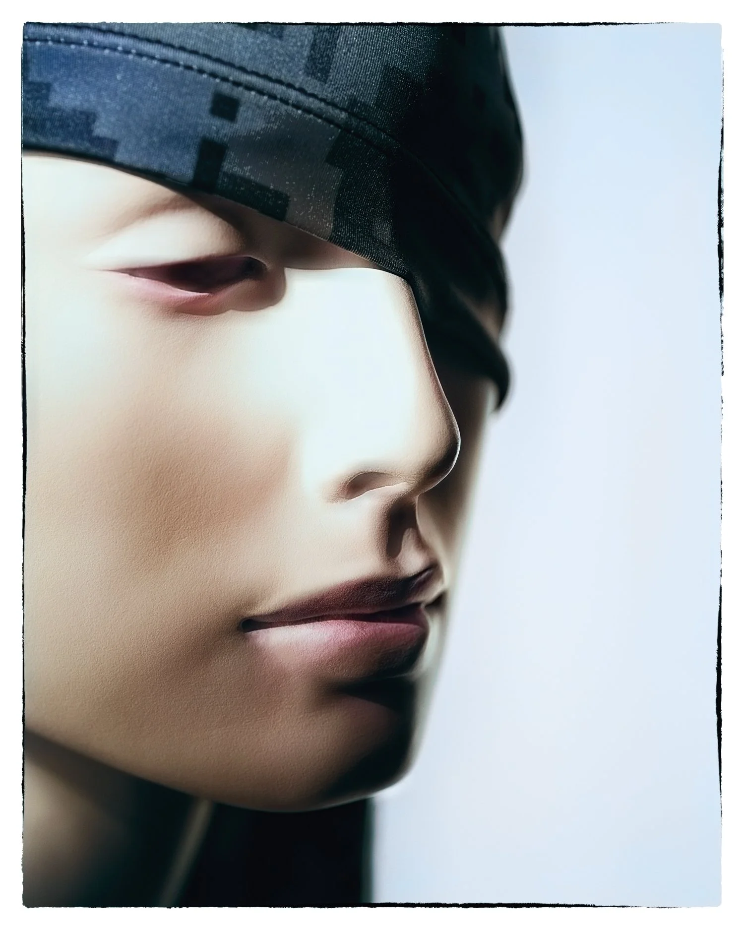 Close-up of a mannequin's face wearing a dark hat, focusing on lips, nose, and one eye.
