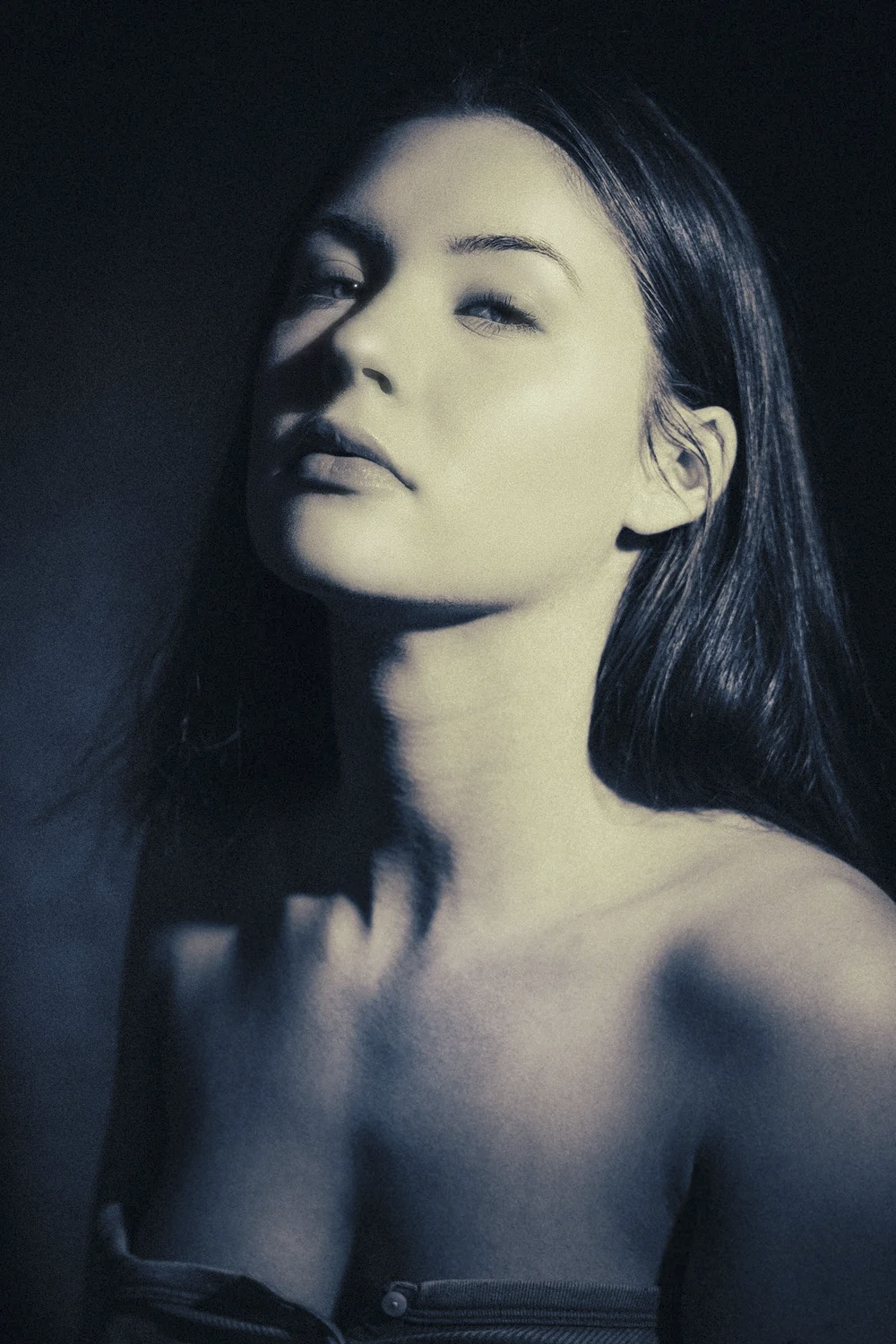 A black-and-white portrait of a woman with shoulder-length hair, one eye closed, and her lips slightly parted.