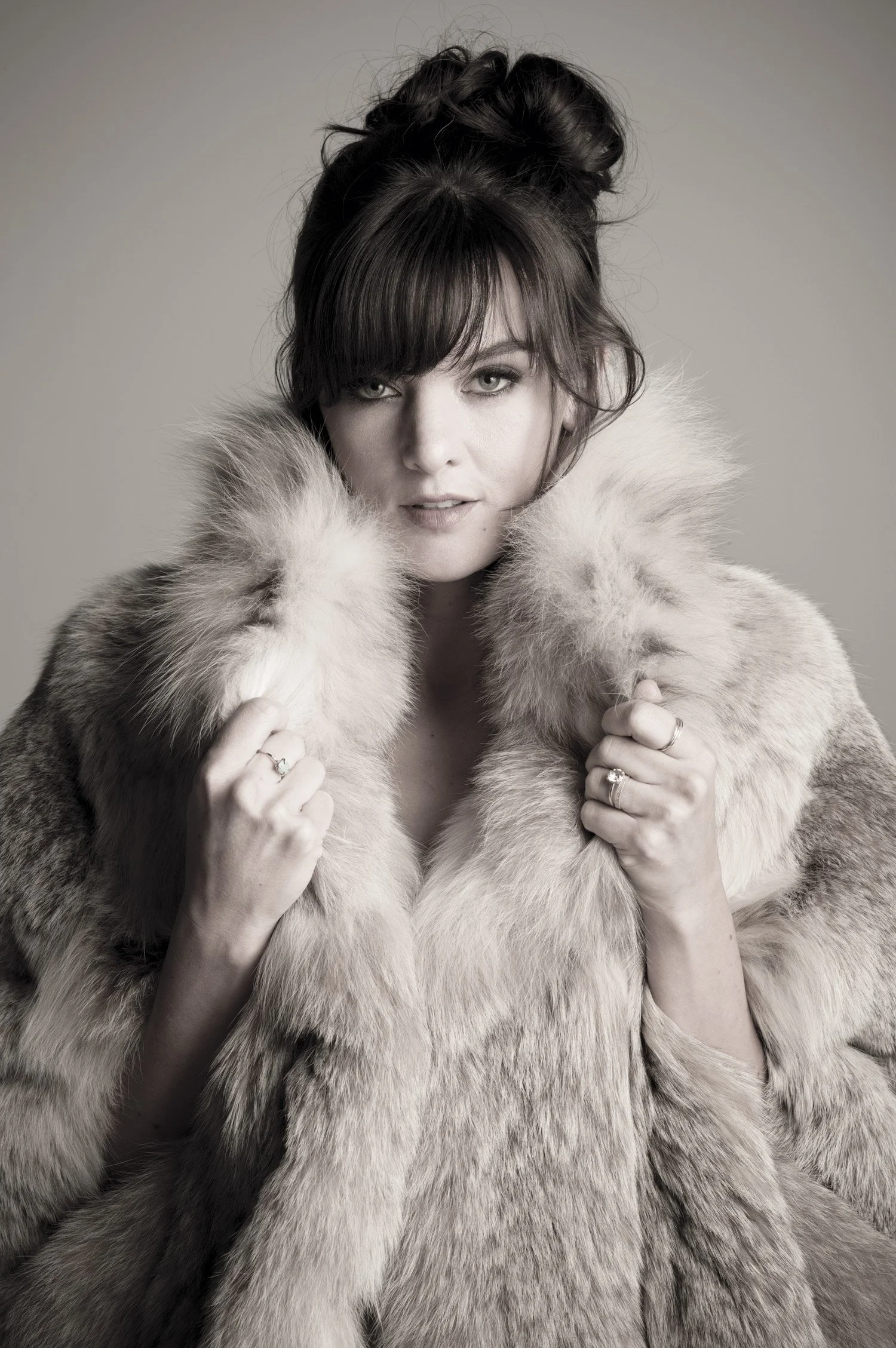 Actor Frankie Shaw wears a faux fur coat for a magazine cover portrait. Her hair is pinned up and she looks directly into the camera.