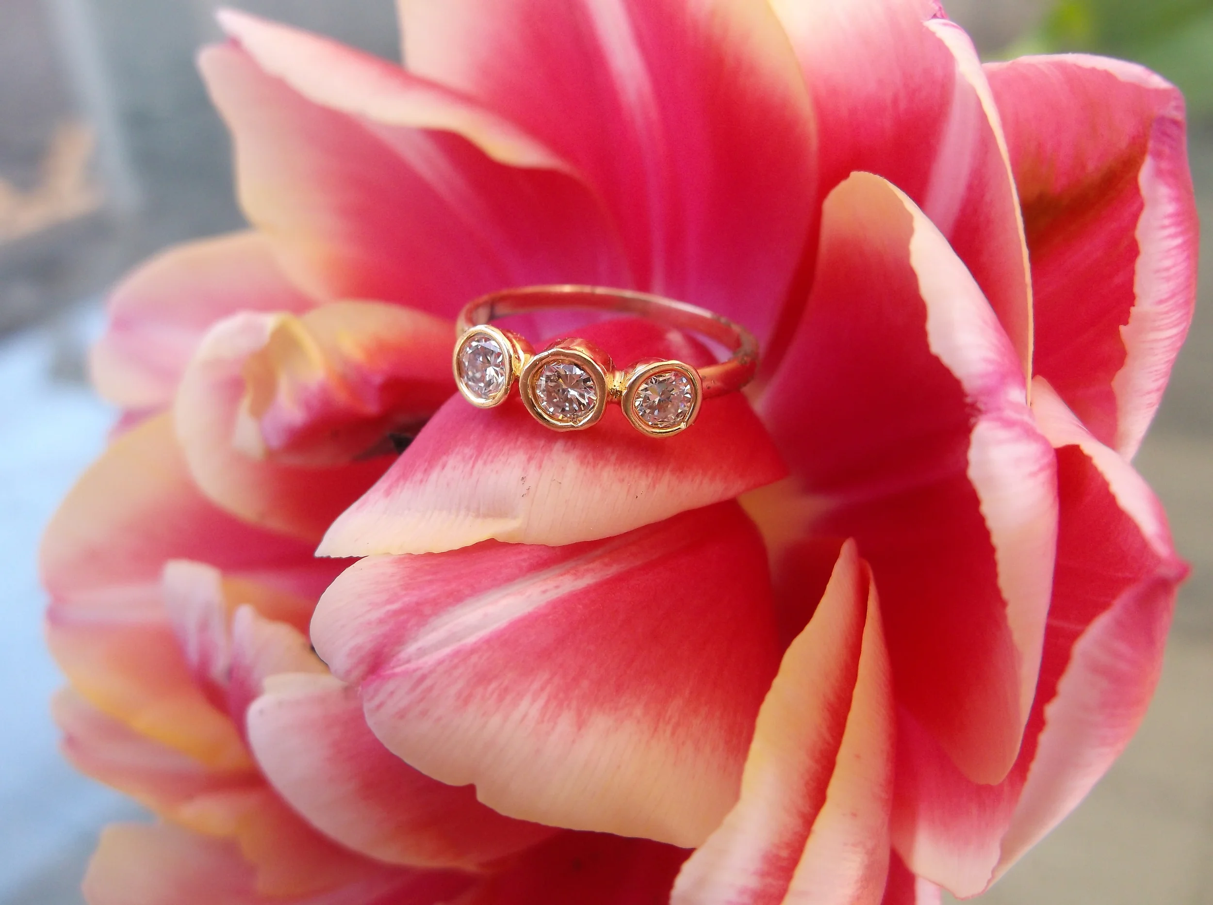 SOLD - Dainty three stone diamond ring set in a 14K yellow gold bezel moutning with 0.30 carats total weight in diamonds.