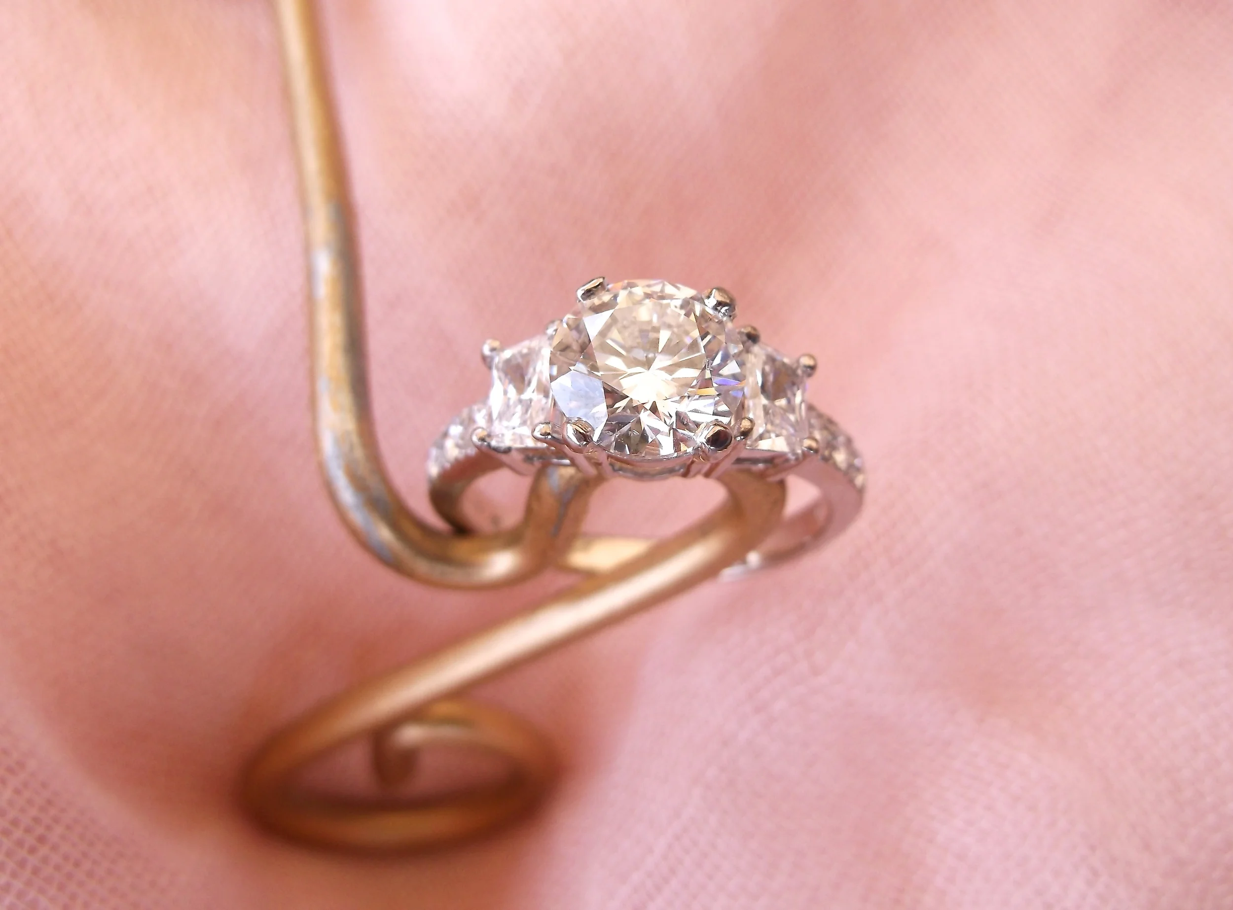 SOLD - Exquisite 1.51 carat round brillant cut diamond set in 18K white gold with a trapezoid cut diamond and small round diamonds on each side. 