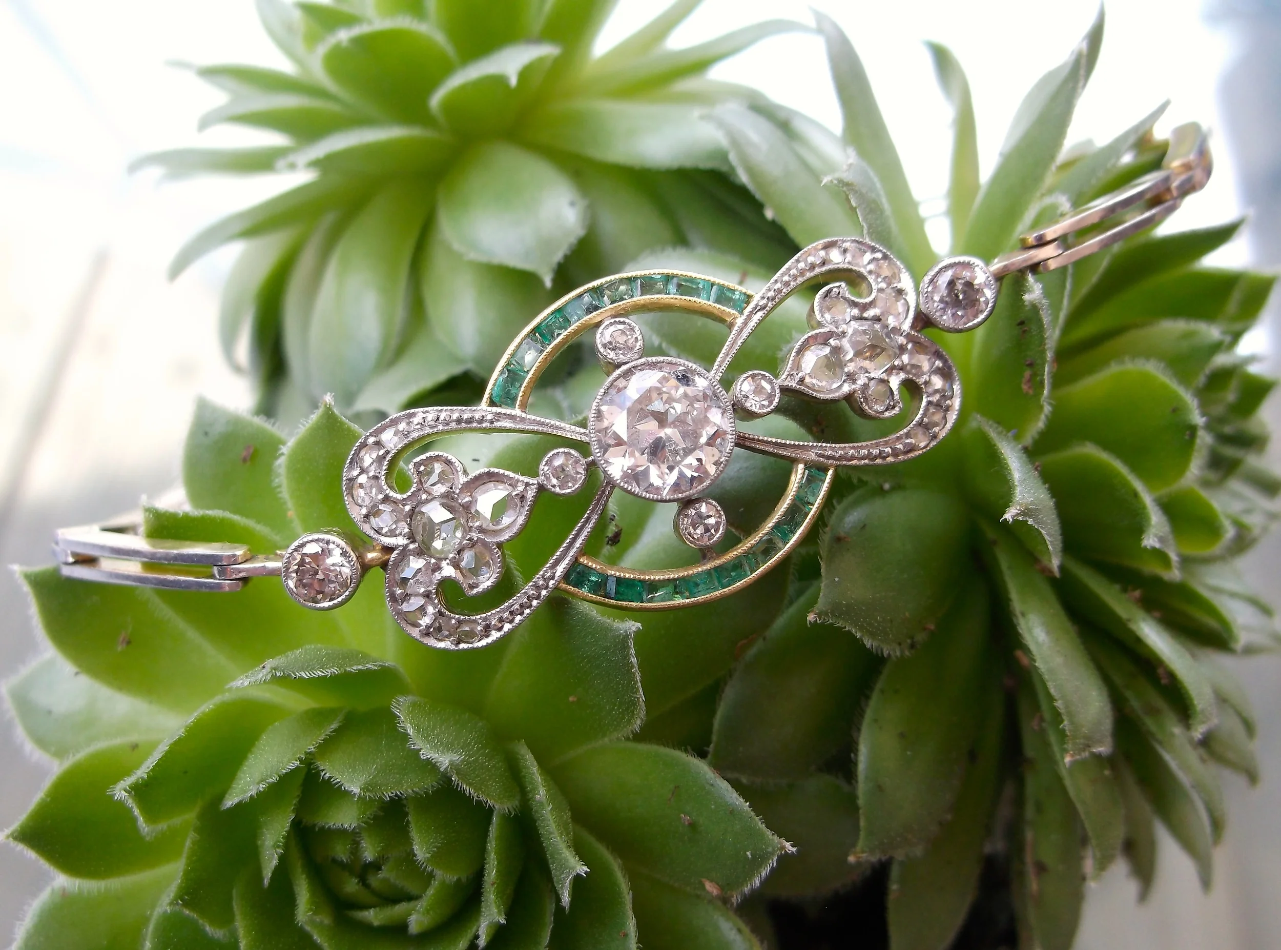 SOLD - tunning Edwardian Era Old European cut diamond and emerald detail bracelet set in platinum topped gold with a 1.15 carat Old European cut diamond in the center. 