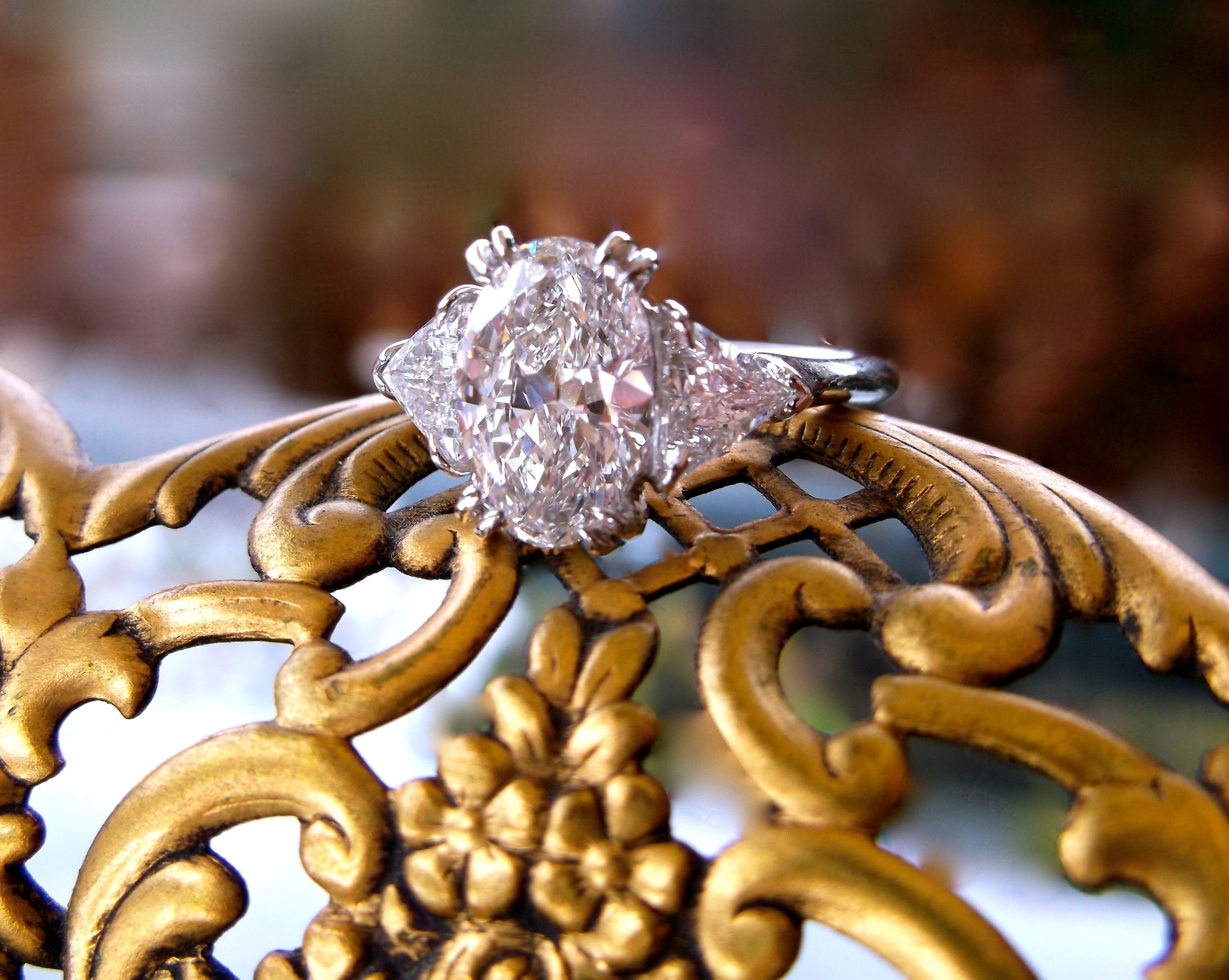 SOLD - Breathtaking Harry Winston diamond ring set in platinum with a 1.54 carat oval in the center and a 0.33 carat trillion cut diamond on each side.