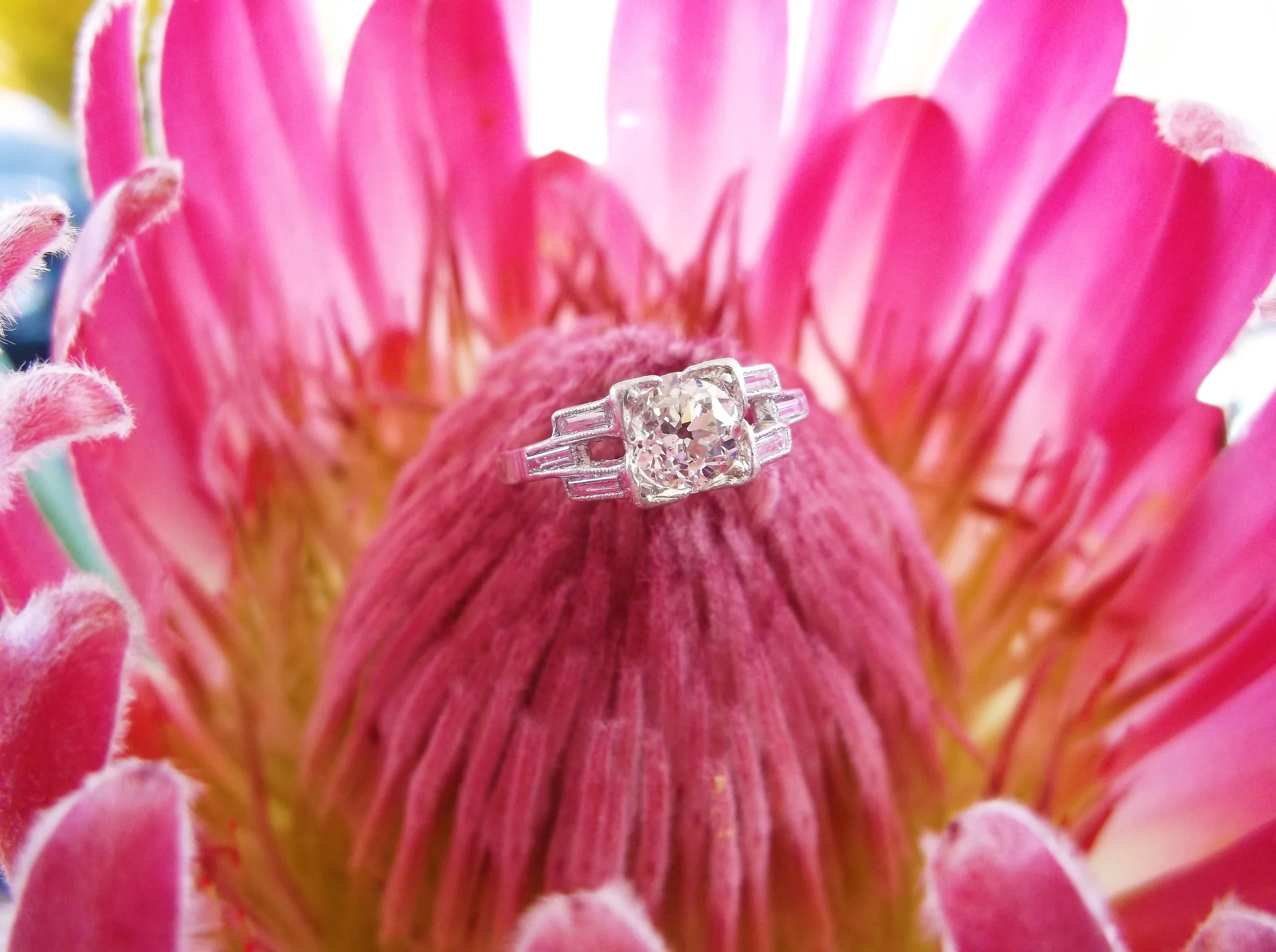 SOLD - Structural Art Deco diamond and platinum ring with a 0.75 carat Old European cut diamond in the center flanked by three baguette cut diamonds on each side.
