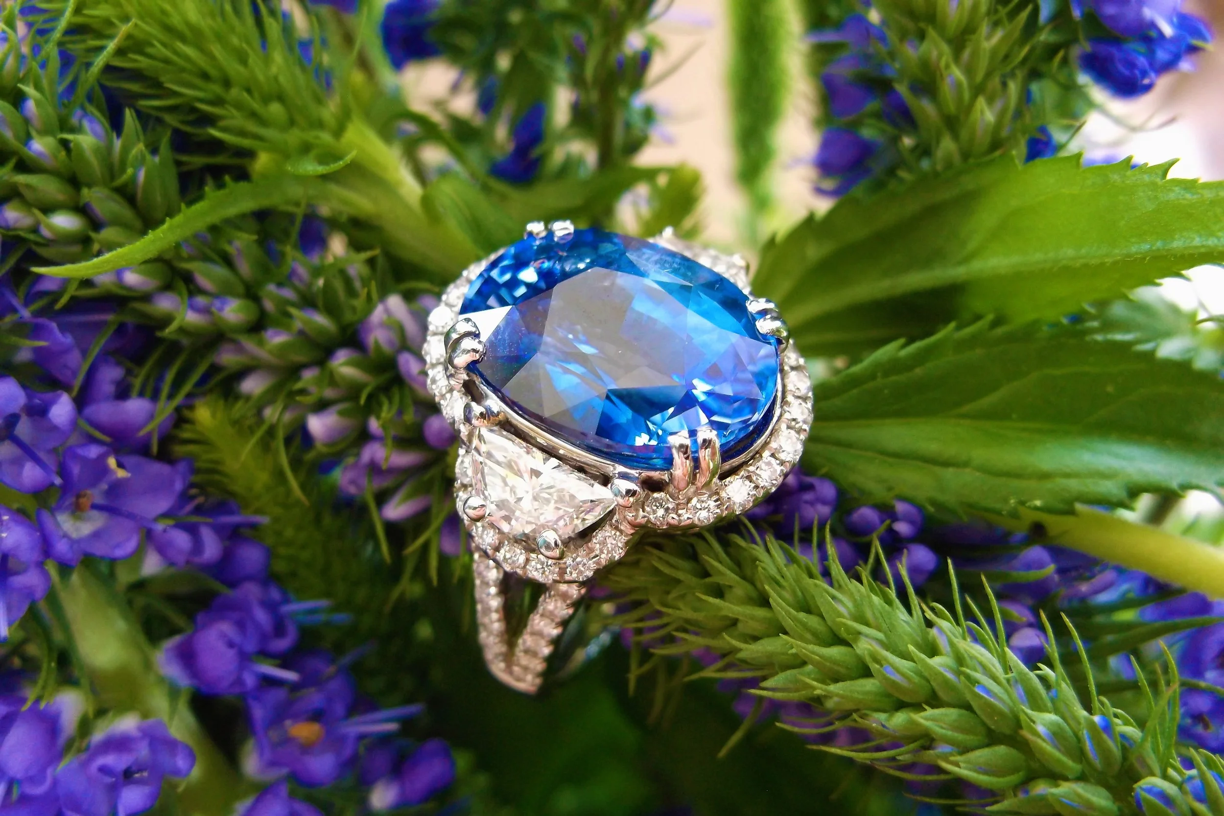 Stunningly gorgeous 8.52 carat sapphire with a half moon shaped diamond on each side surrounded by round diamonds set in white gold (1.24 carats total weight in diamonds!).