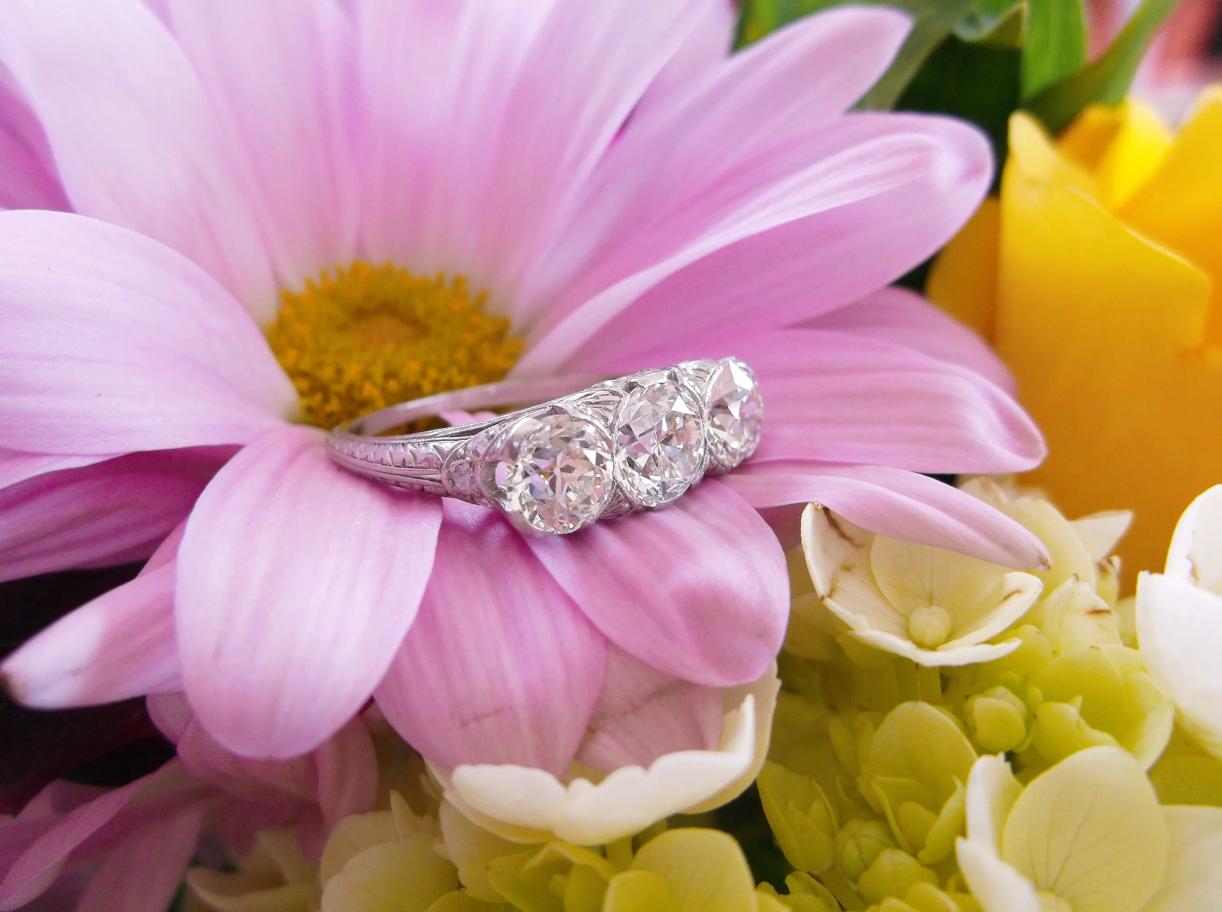 SOLD - Beautiful 1920's Old European cut three stone diamond ring set in platinum with 2.53 carats total weight in diamonds. (The center diamond is 1.06 carats, 0.68 carat diamond on one side and a 0.79 carat diamond on the other.)