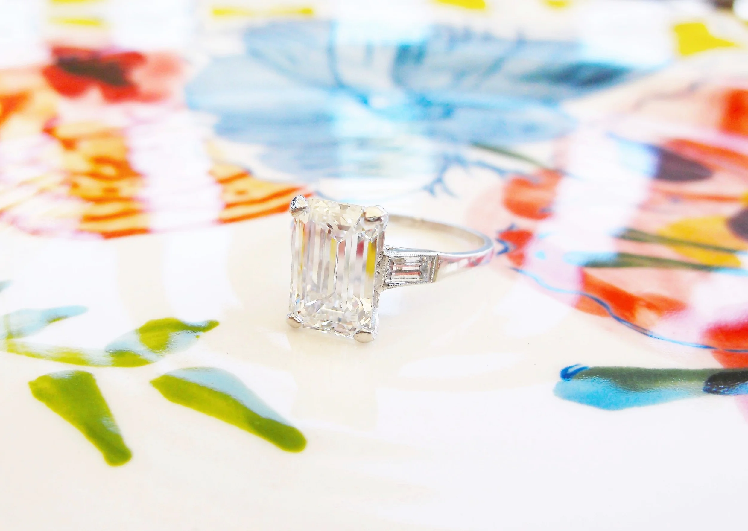 SOLD - Breathtaking 2.58 carat emerald cut diamond set in a beautiful platinum and bezel set baguette cut diamond detail mounting.