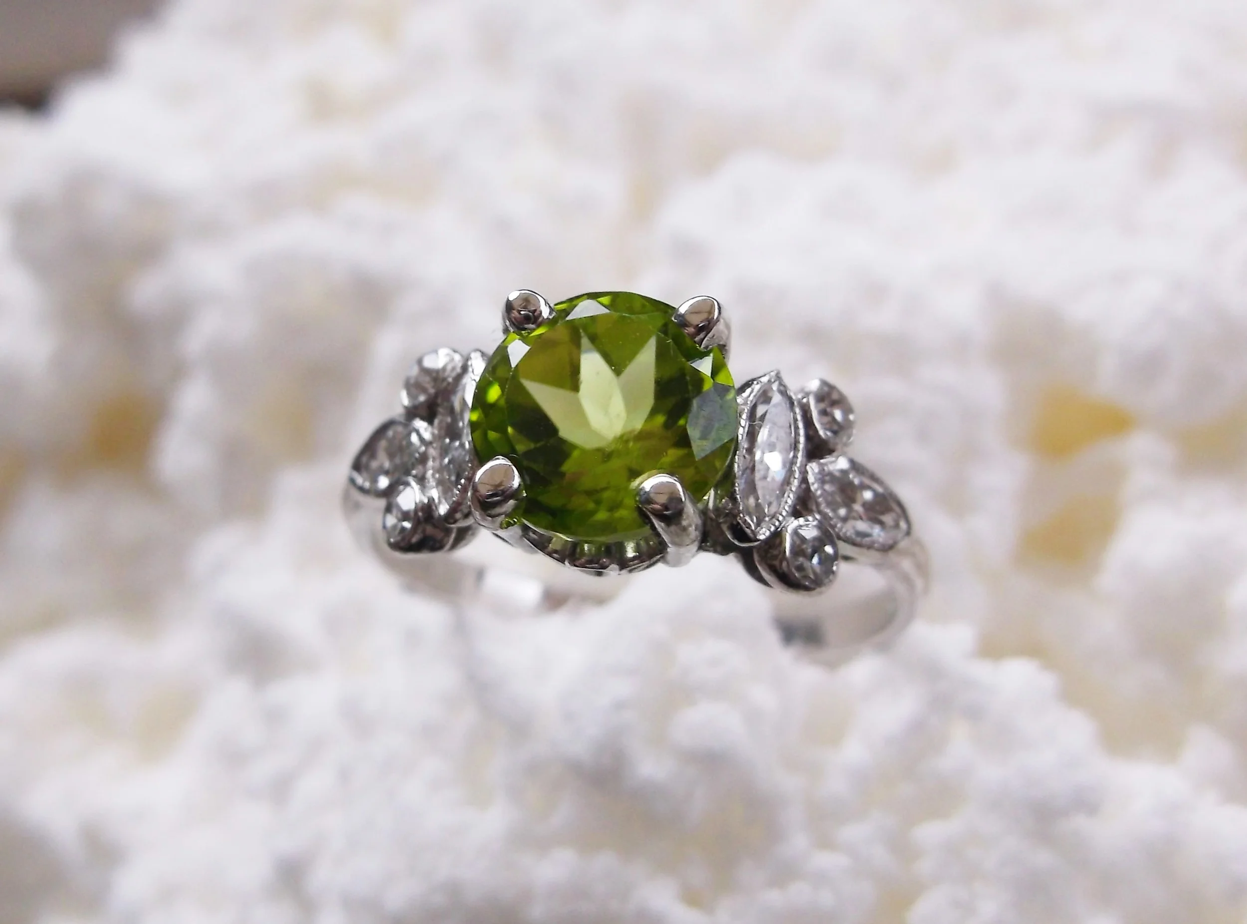 SOLD - Electric green 1.36 carat peridot with 0.40 carats total weight in diamonds set in platinum.