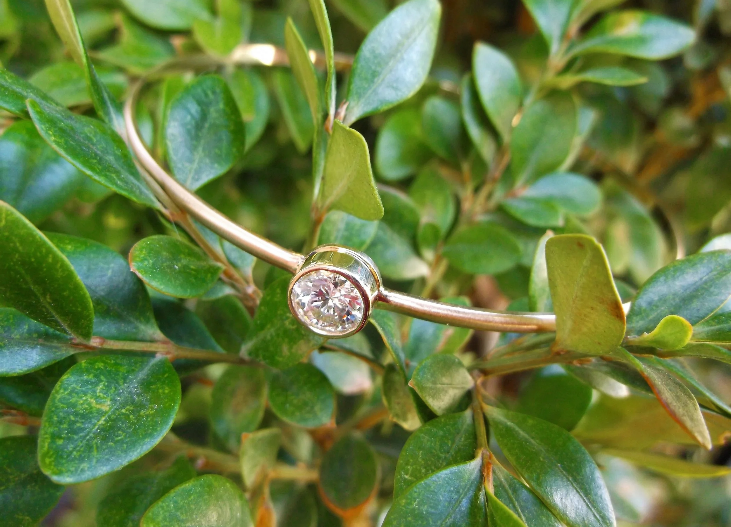 Pair this bracelet with others in your collection for effortless style or wear it on its own for a simply chic look! 0.90 carat round brilliant cut diamond, bezel set on a classic matte finished gold bangle bracelet.