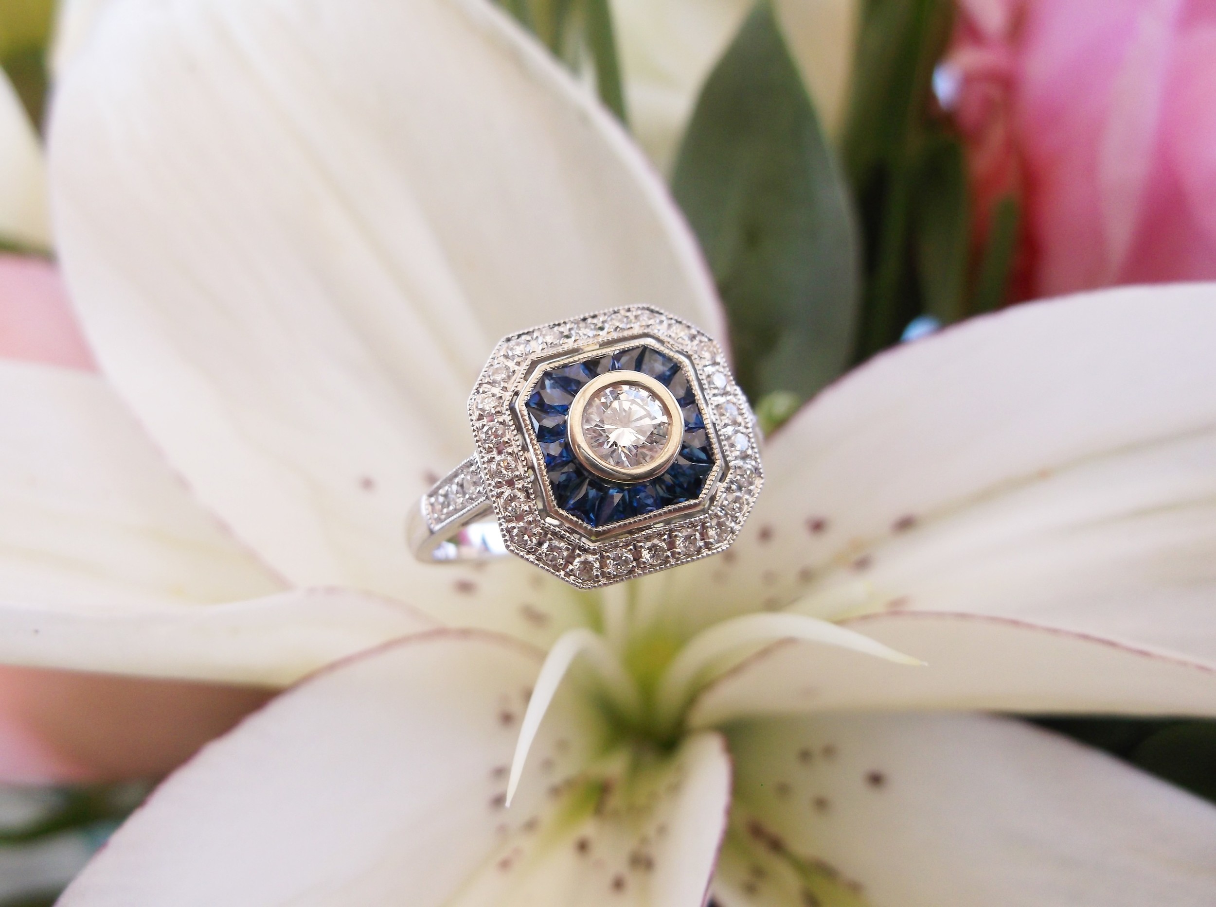 SOLD - Captivating diamond and sapphire ring with a 0.20 carat round brilliant cut diamond in the center set in white gold.